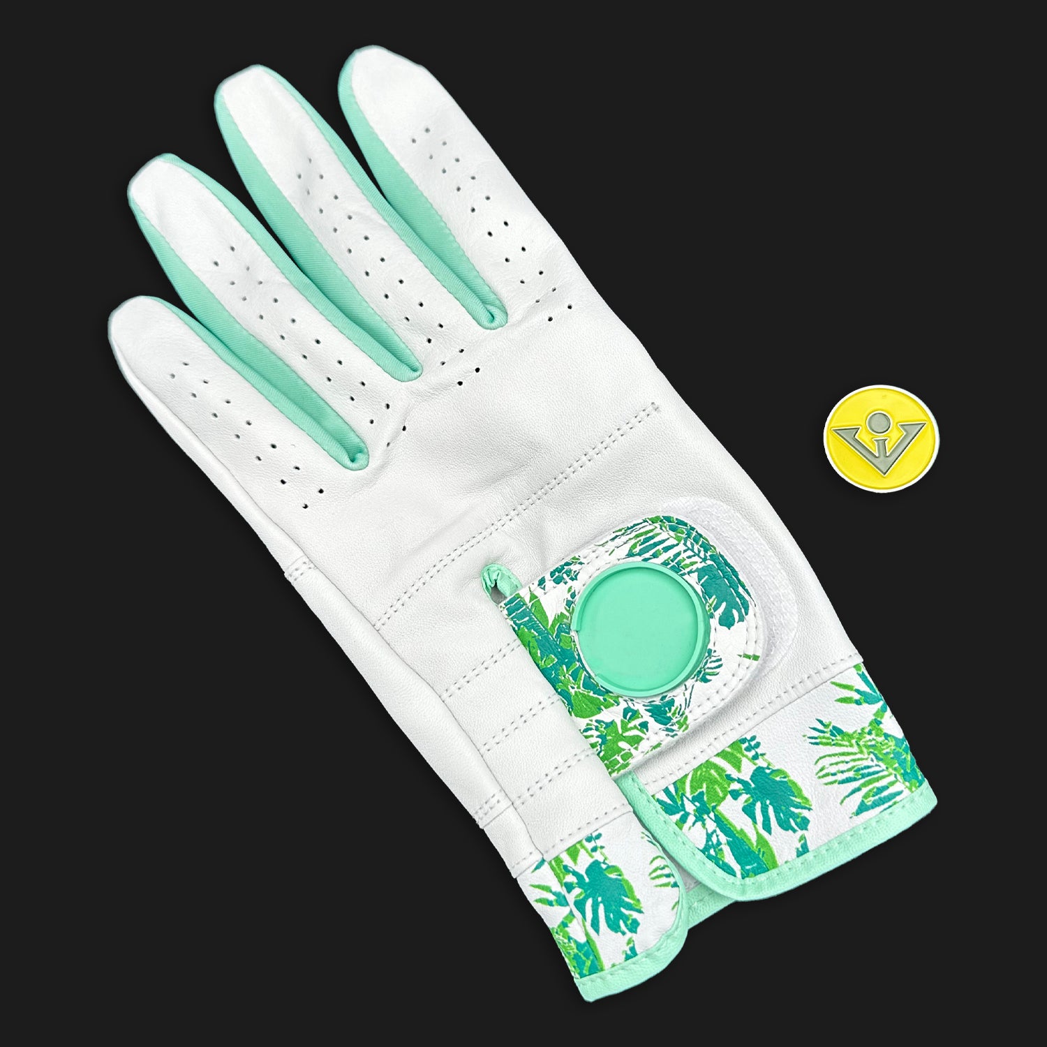 White golf glove with green floral pattern on a black background
