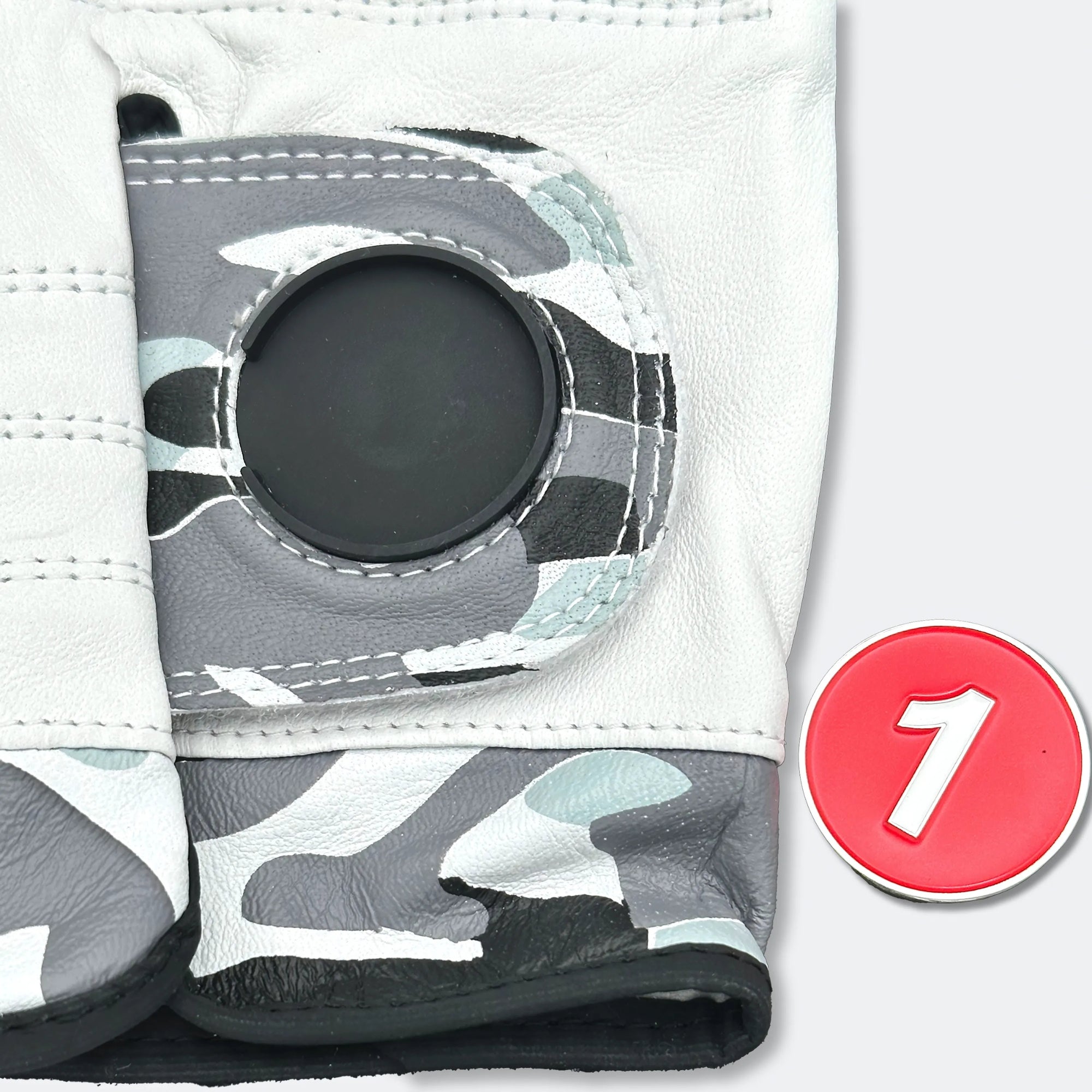 Camo golf glove with on a white background with magnetic ball marker out of the cavity.