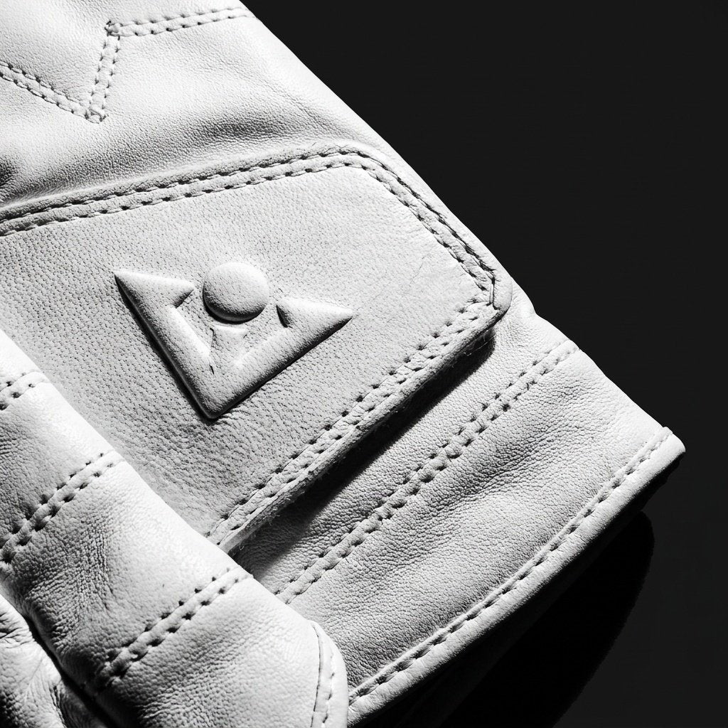 Close-up of a white golf glove with brand logo on a black background