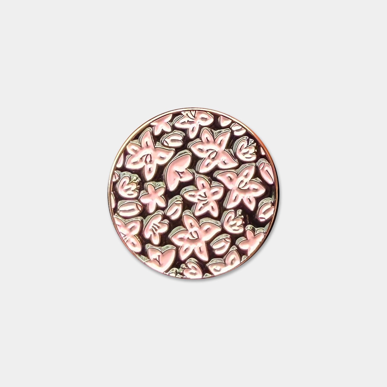 Circular ball marker with azalea floral pattern on a light gray background