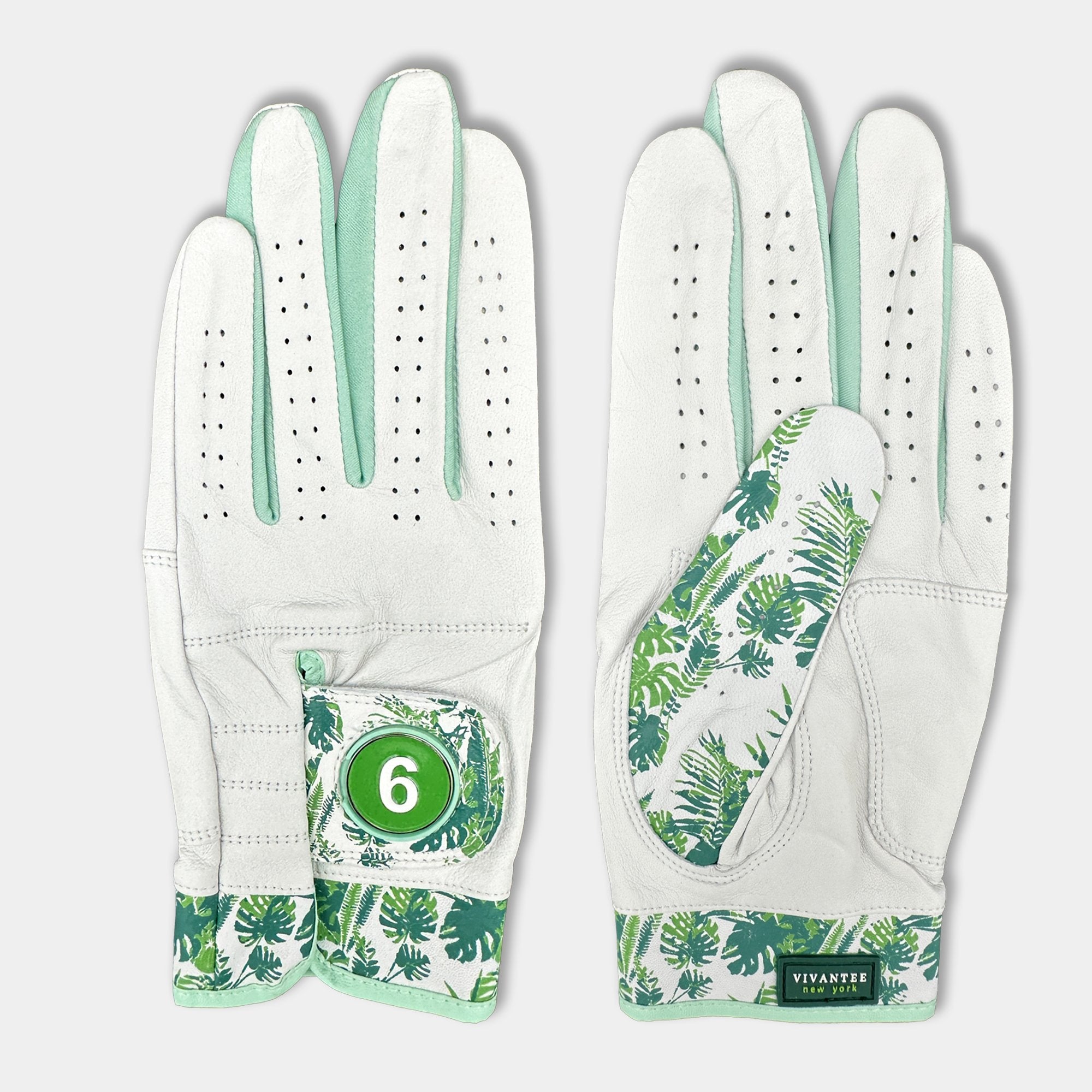 White golf glove with green leaf pattern and number 6 on a light gray background