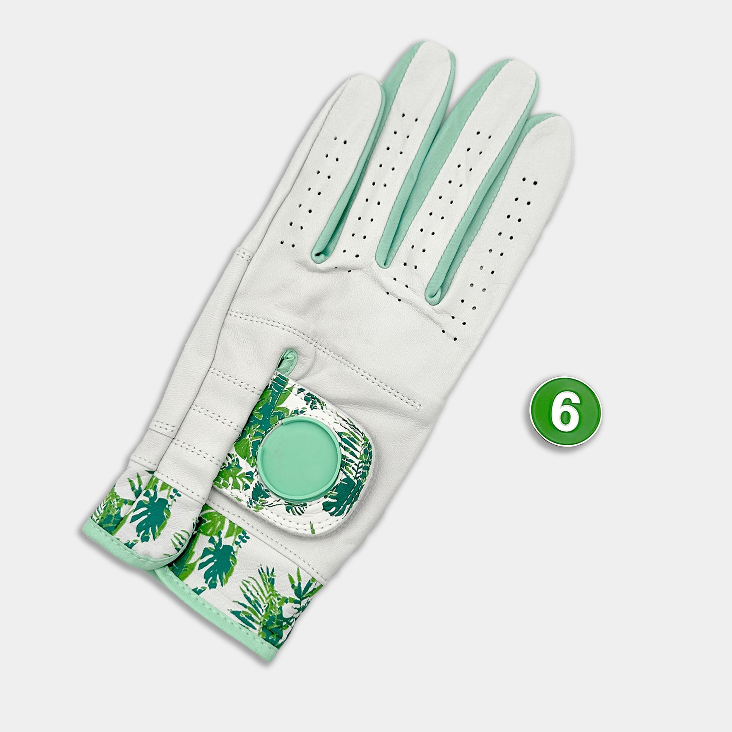 Golf glove with a tropical pattern and a green ball marker on a white background