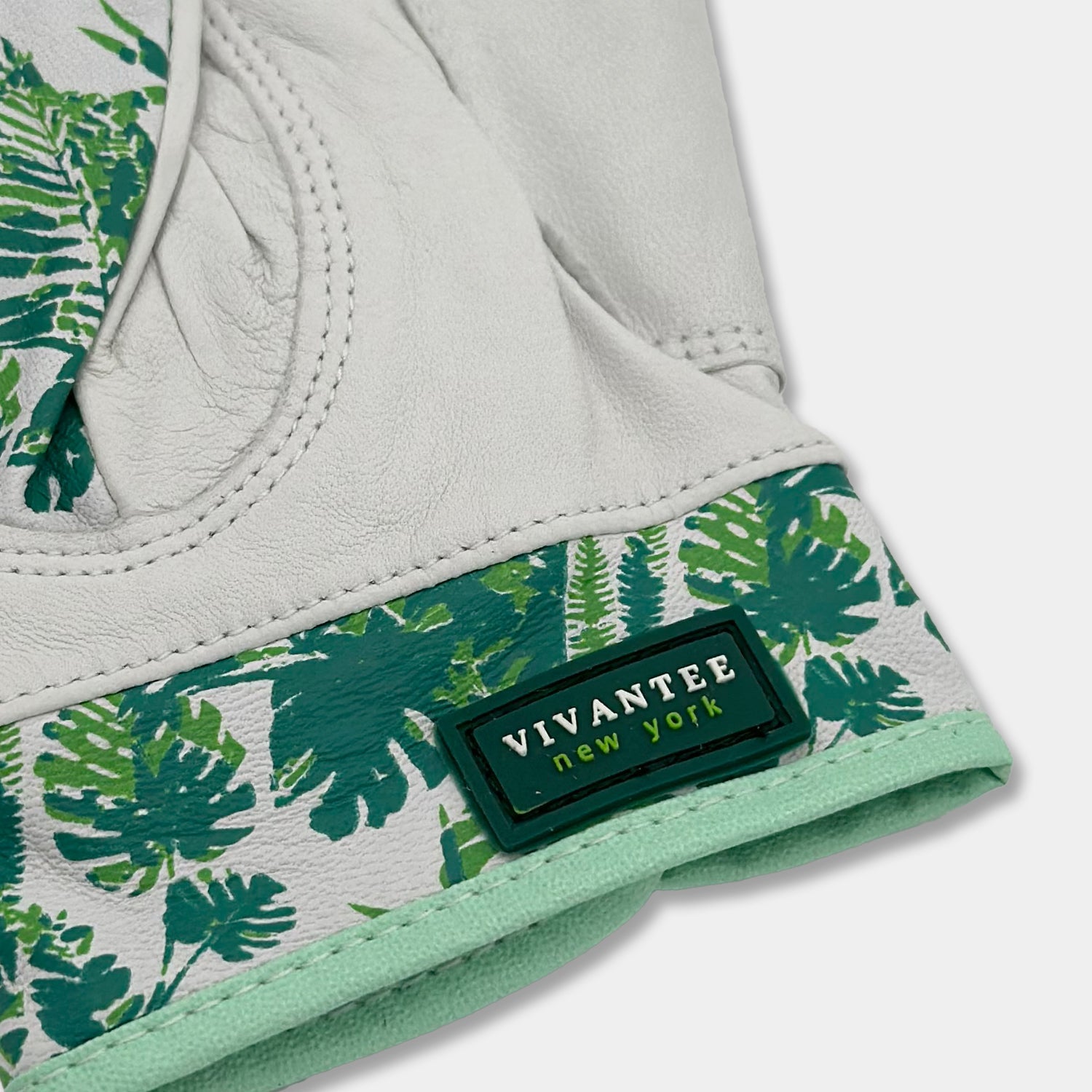 Close up of the tag saying VivanTee New York on a white and green golf glove.