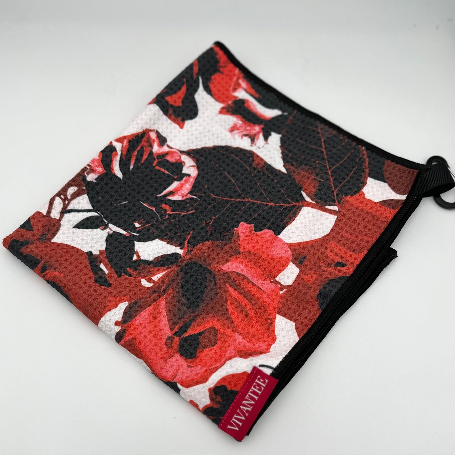 Backside of VivanTee's floral print magnetic golf towel in red and black.