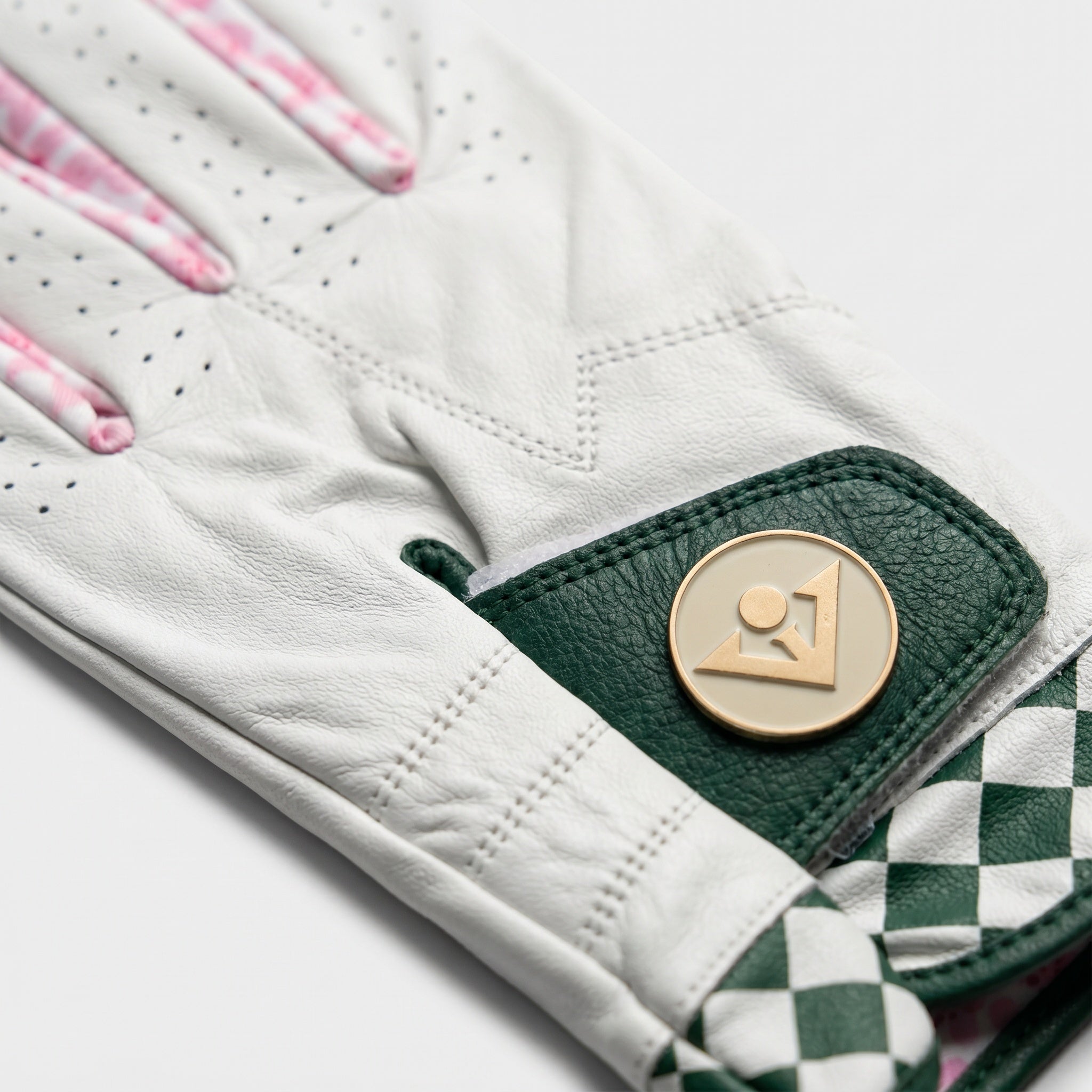 Golf glove with green checkered board and magnetic ball marker in gold.