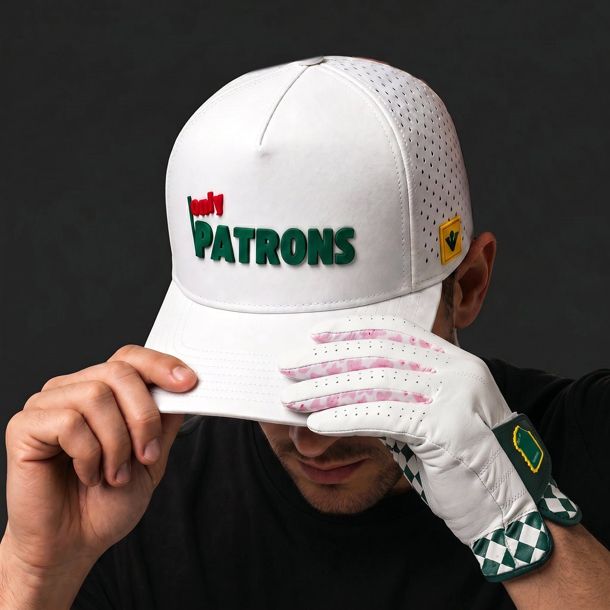 Male model putting on a performance golf hat that says "Only Patrons".