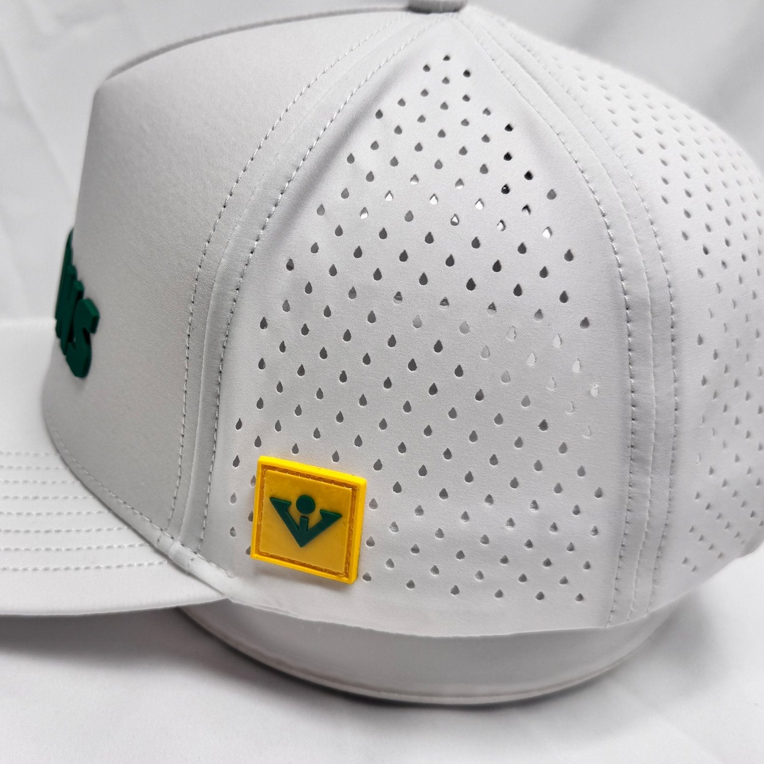 White perforated golf cap with a yellow patch featuring a green vivantee logo on a white background
