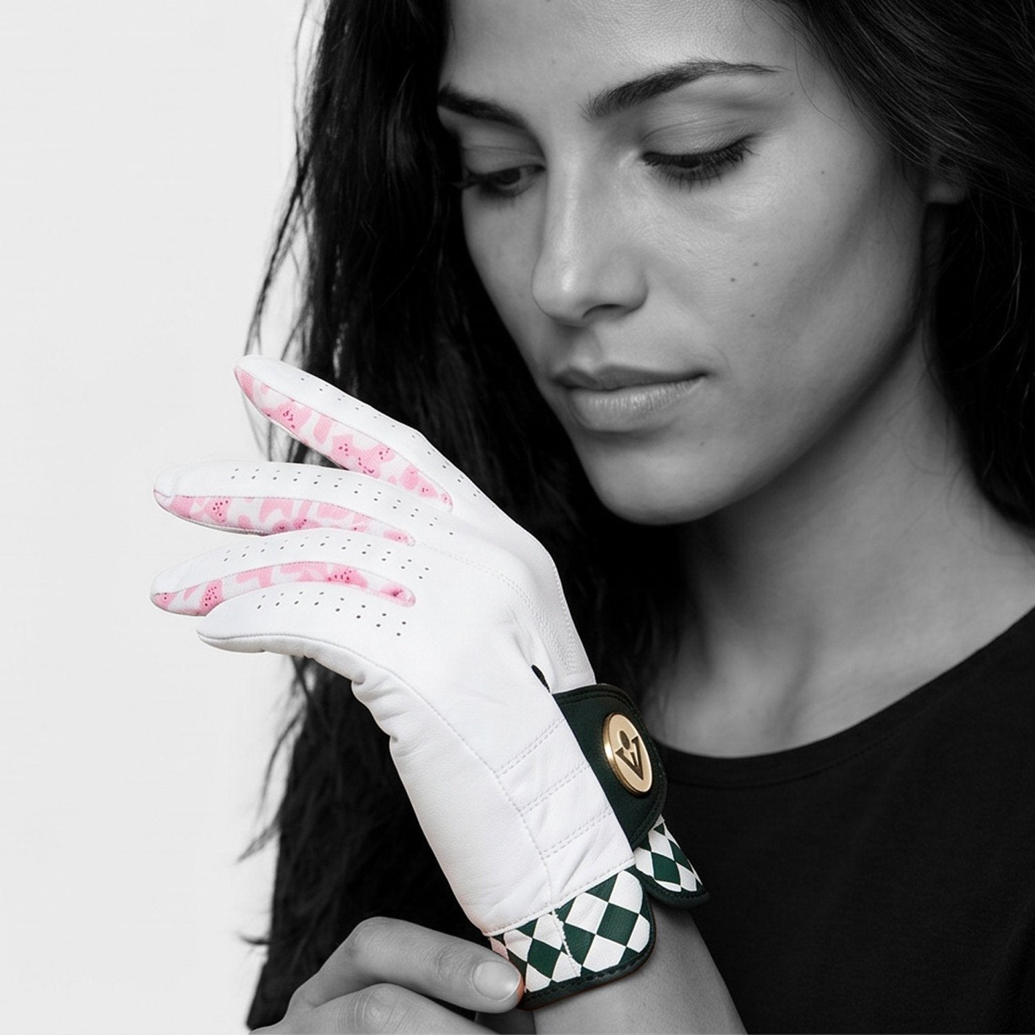 Woman wearing a green and pink golf glove in black and white background.