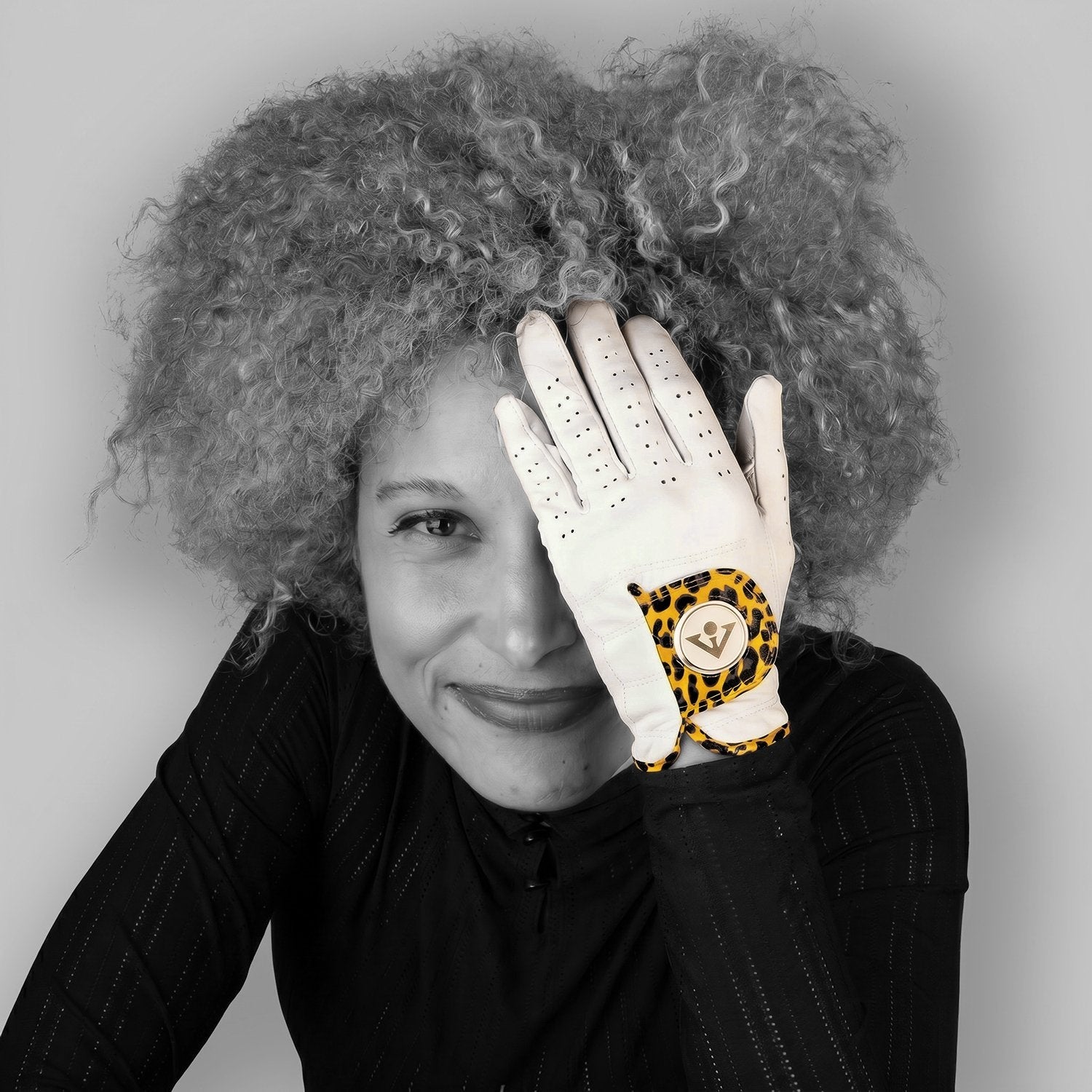 Person wearing a white glove with a leopard print design on a gray background