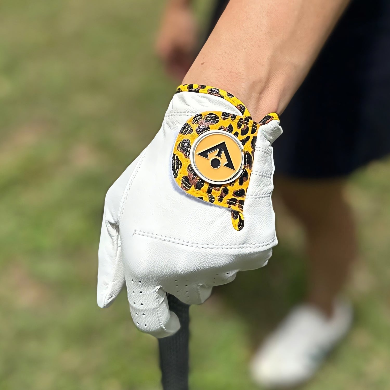 Woman posing with a cheetah print golf glove with magnetic ball marker.