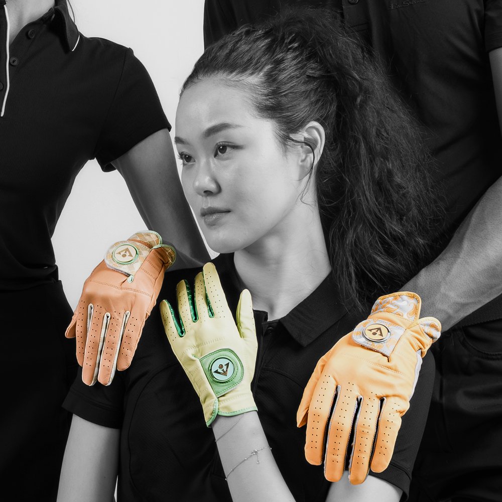 A model looking off into the distance with Various designer colored golf gloves with ball markers on her hand and the hands of the models behind her.