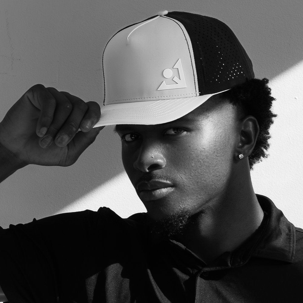 Man wearing a performance golf hat with VivanTee logo in black and white setting.