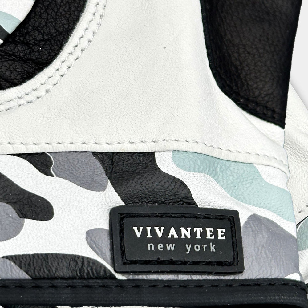 Close-up of a shoe with a Vivantee New York label on a camouflage-patterned background.