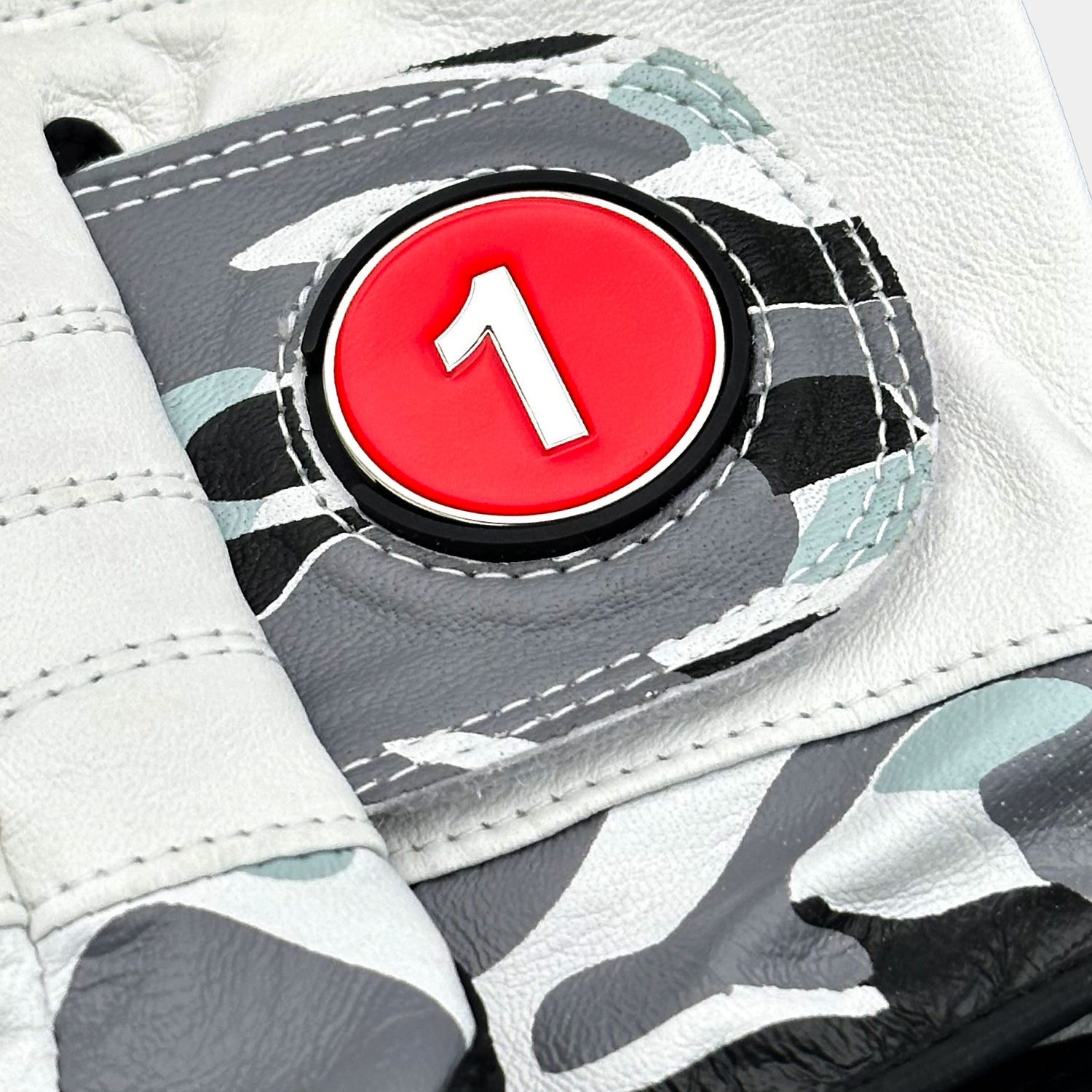 Close-up of a VivanTee Cabretta leather golf glove in gray camouflage with black palm reinforcement, designed for durability, grip, and style on the course.