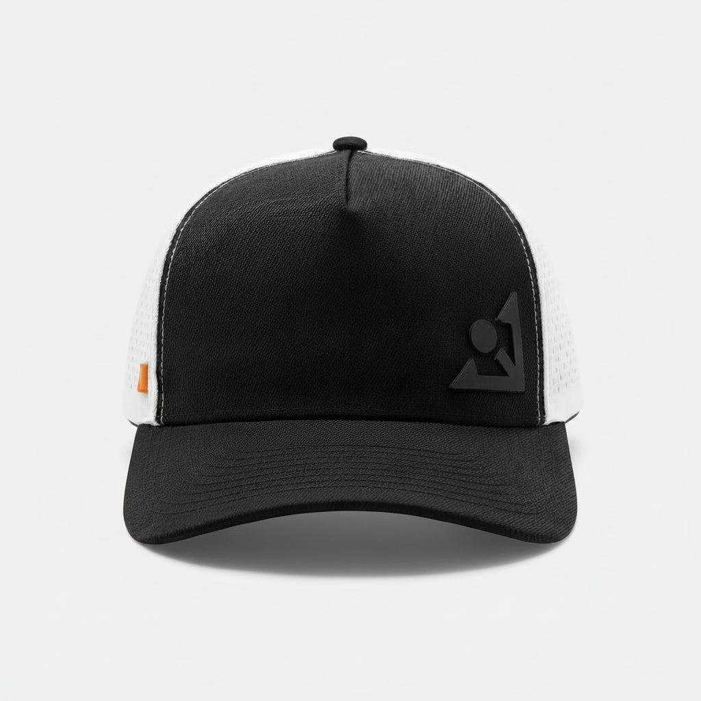 White and black trucker-style golf hat with contrast stitching on the bill, an angular emblem on the front panel, and ventilation holes in the mesh back section.