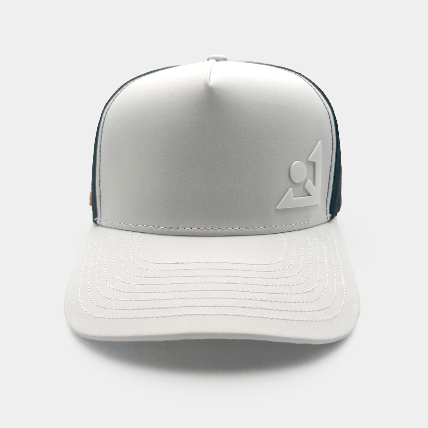 White and black trucker-style golf hat with contrast stitching on the bill, an angular emblem on the front panel, and ventilation holes in the mesh back section.