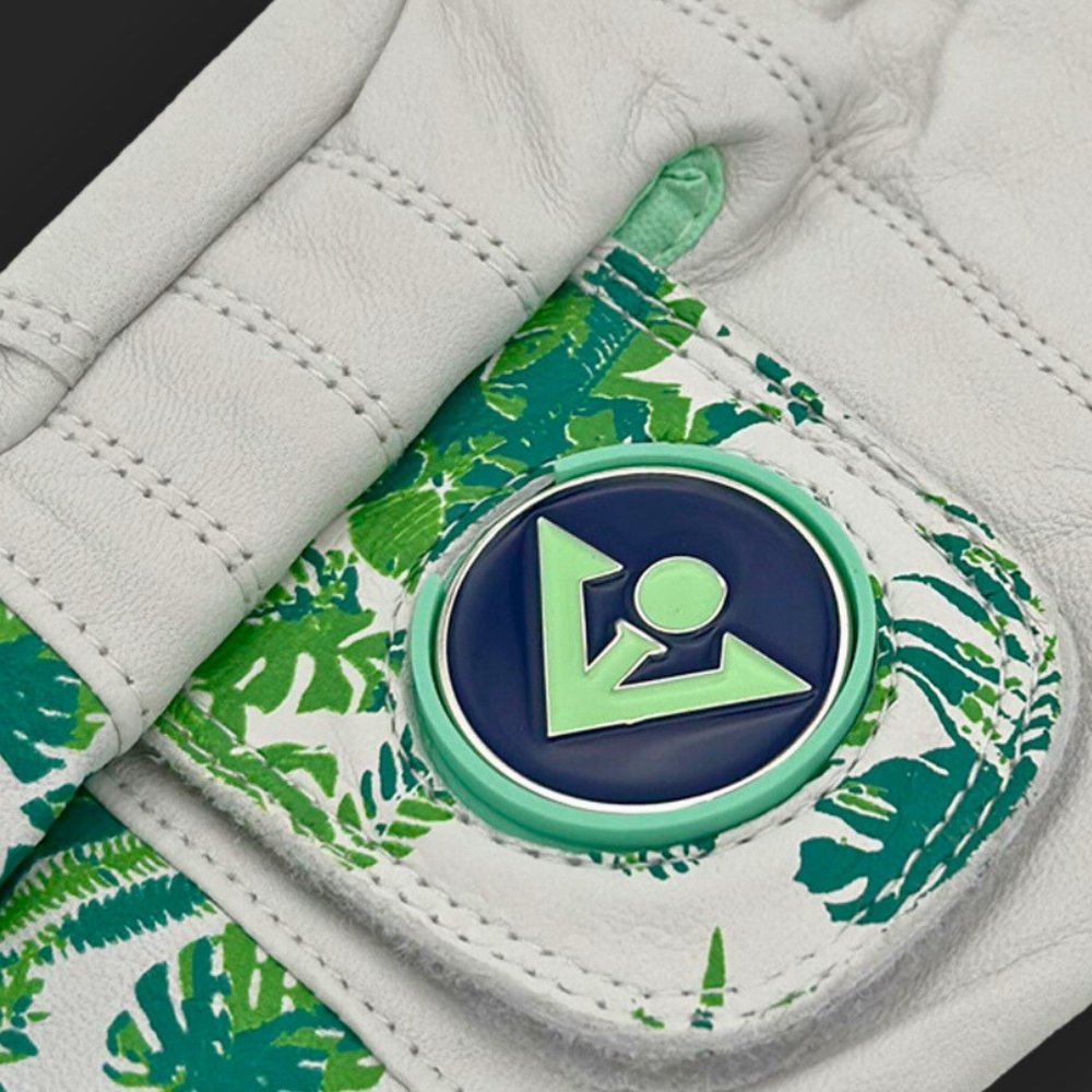 Close-up of a palm golf glove with a ball marker in green and blue showing the premium leather and material.