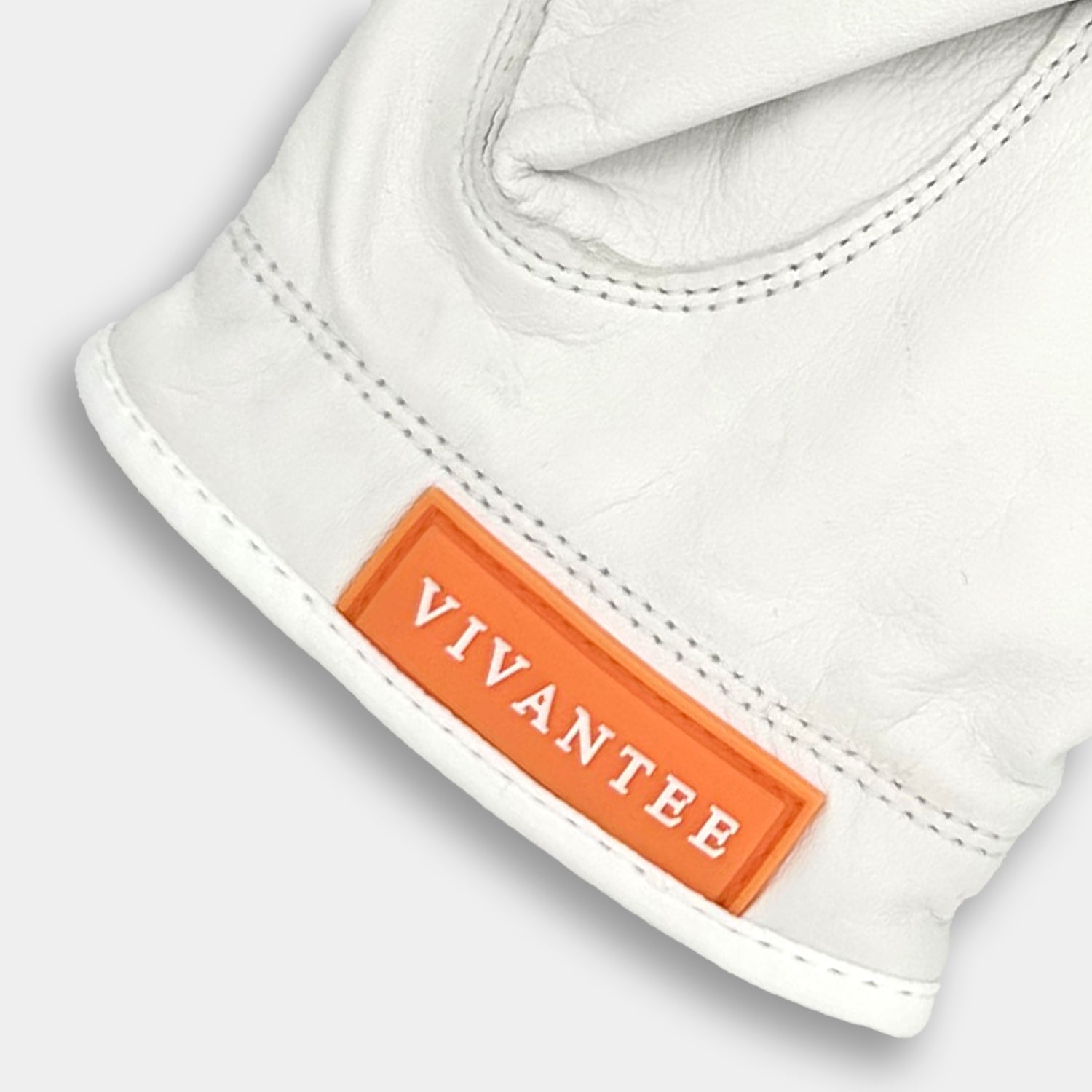 White golf glove with an orange 'Vivantee' label on a light gray background