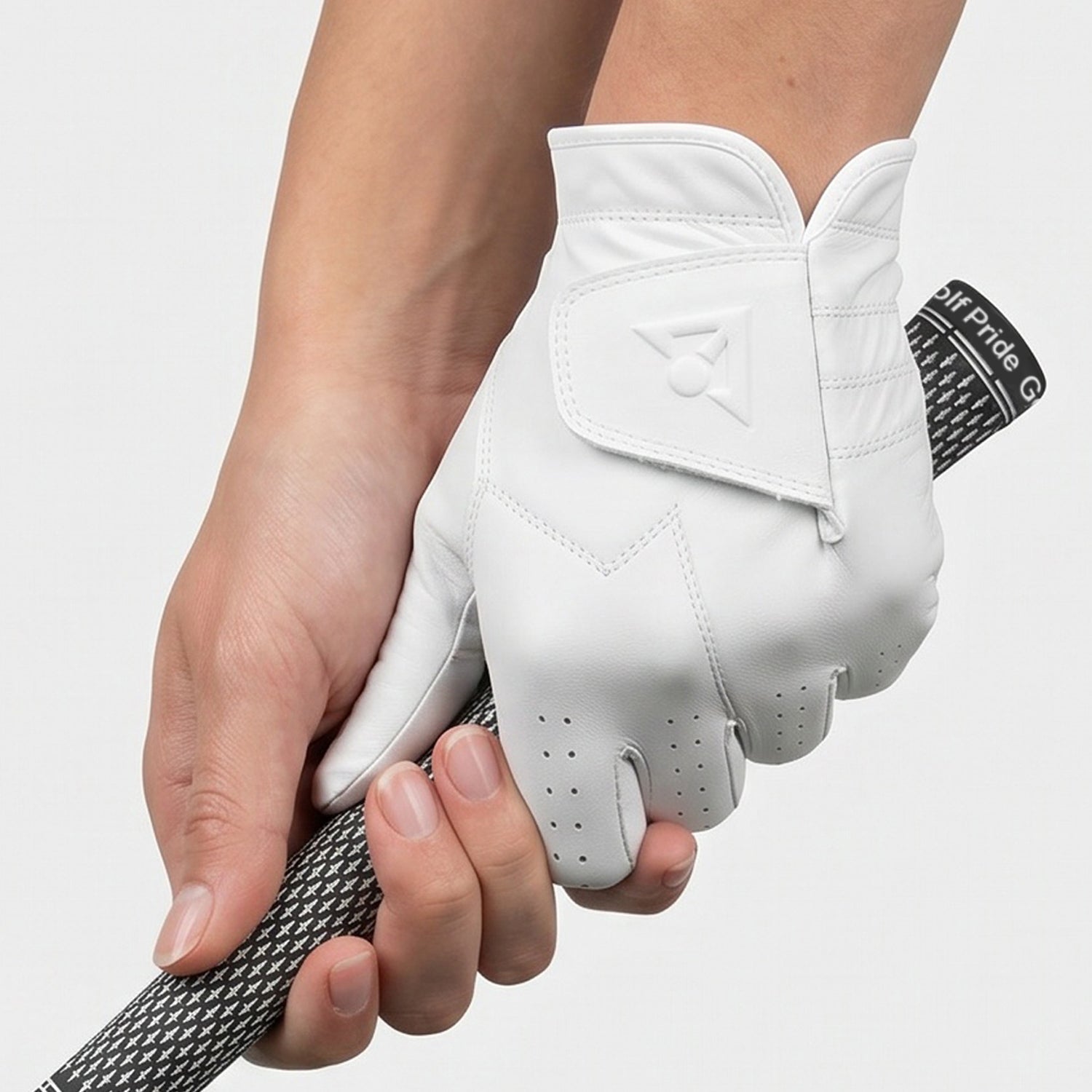 Women's White golf glove on a hand holding a golf club against a light gray background