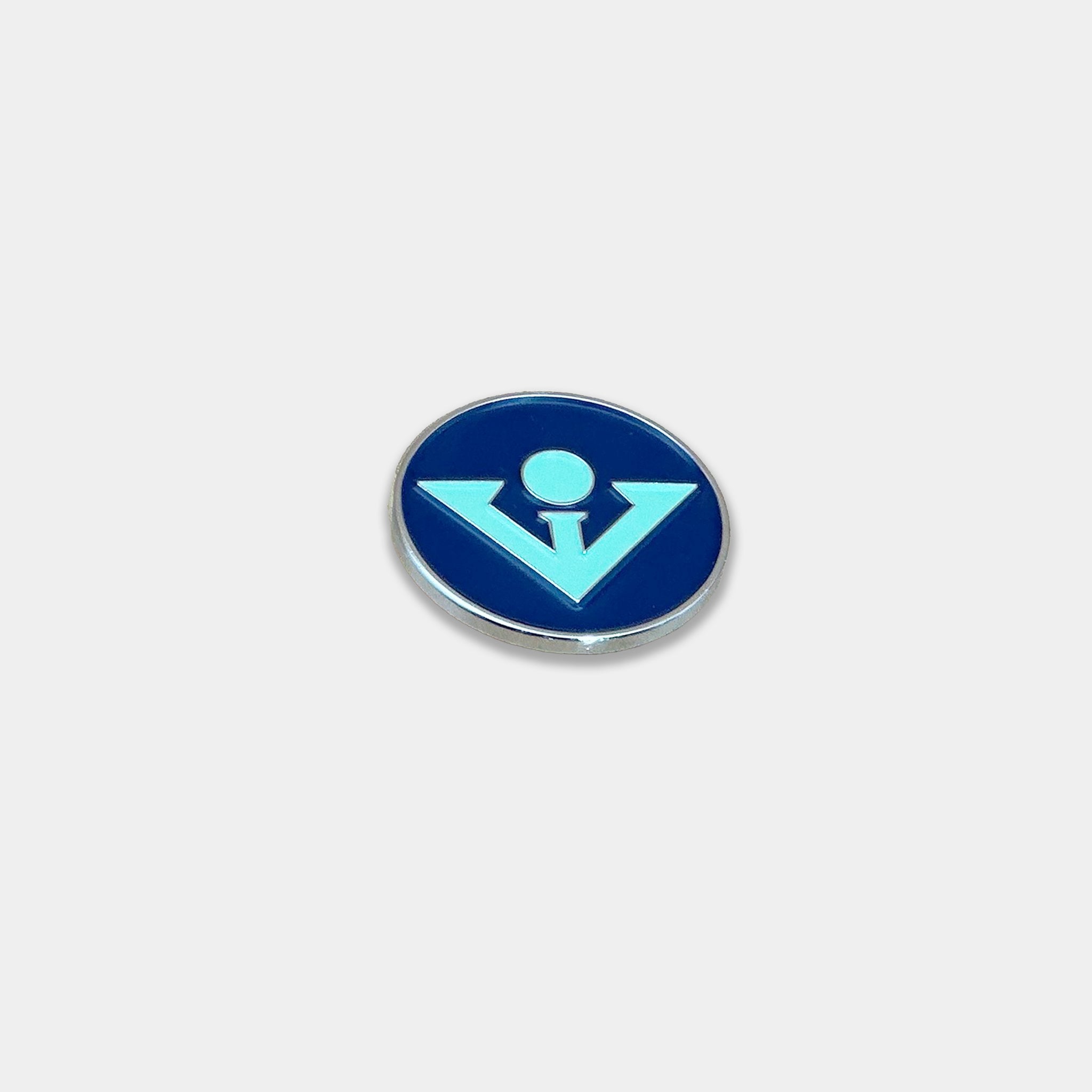 Seafoam blue and mint green golf ball marker on an off white background.