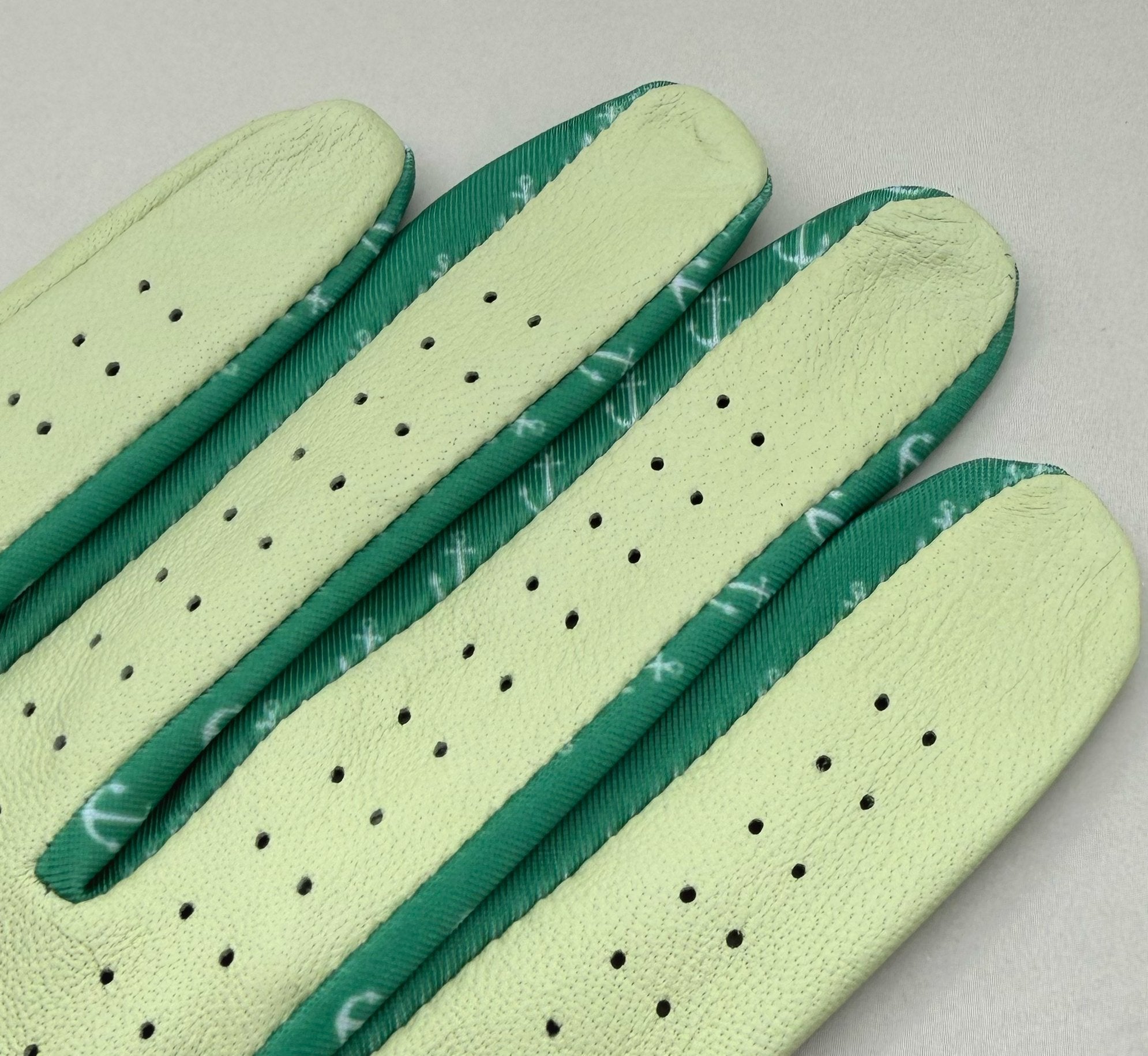 Close up of golf glove fingers with lycra, featuring anchors in green and white.