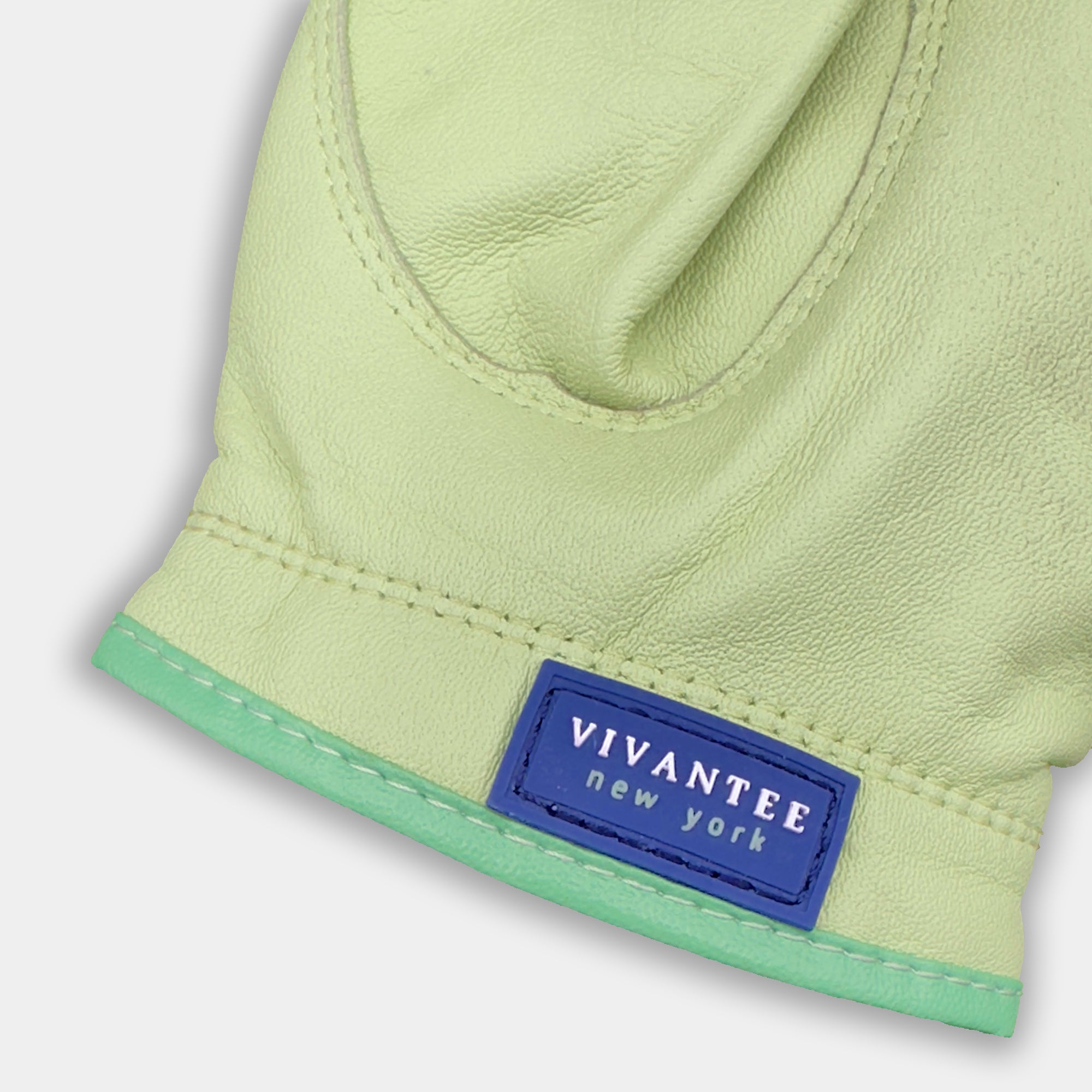 Green leather golf glove with a blue "VivanTee" label on a light gray background.
