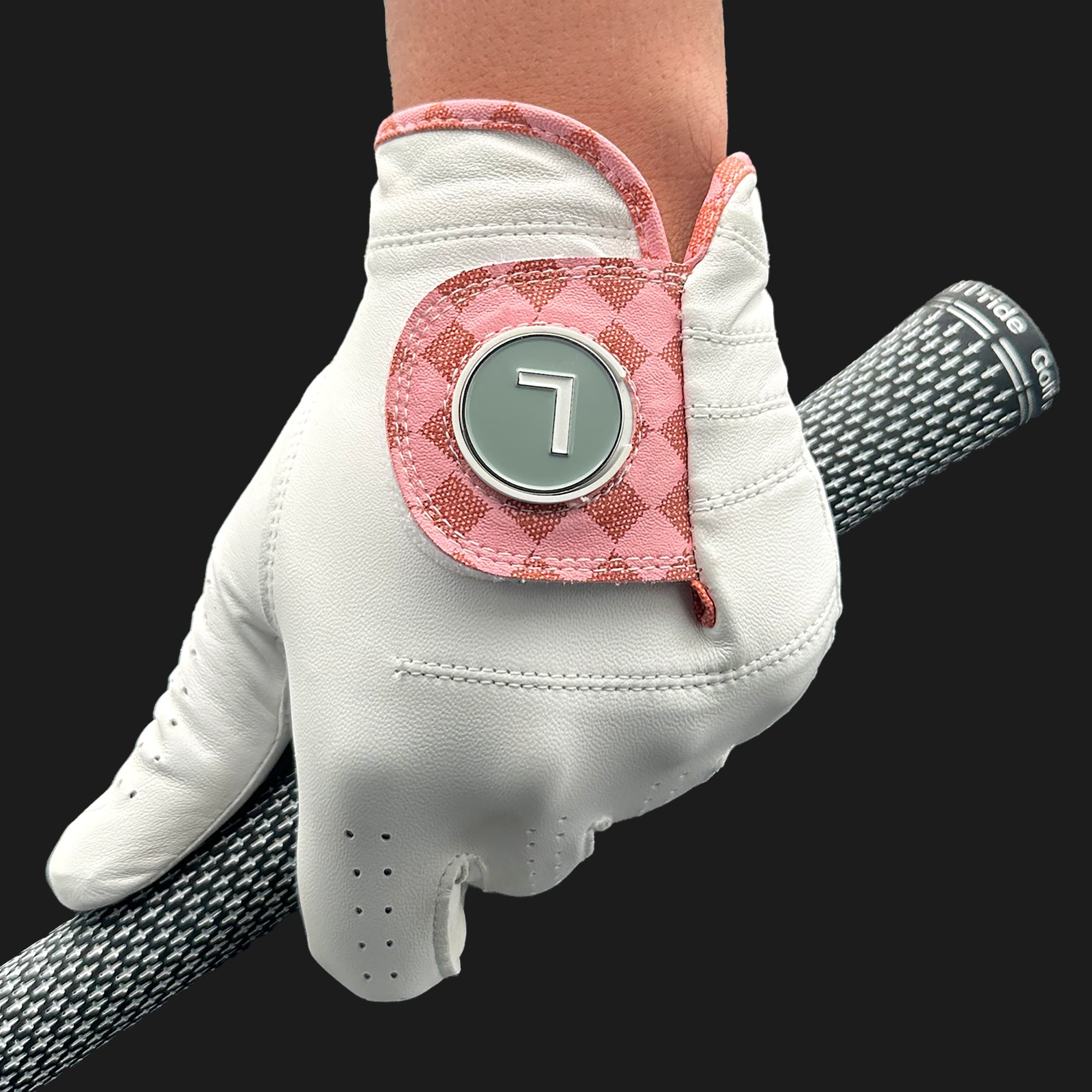 White golf glove with pink accents and a number 7 on a black background