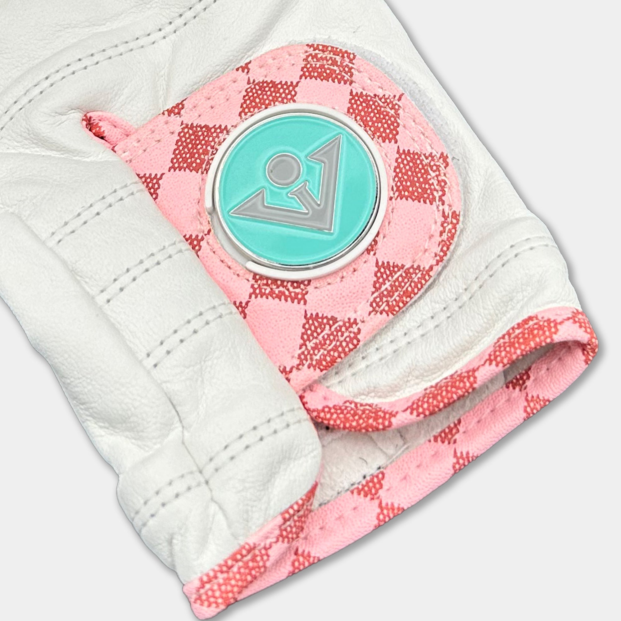 Golf glove with a pink and white checkered palm and a turquoise ball marker.
