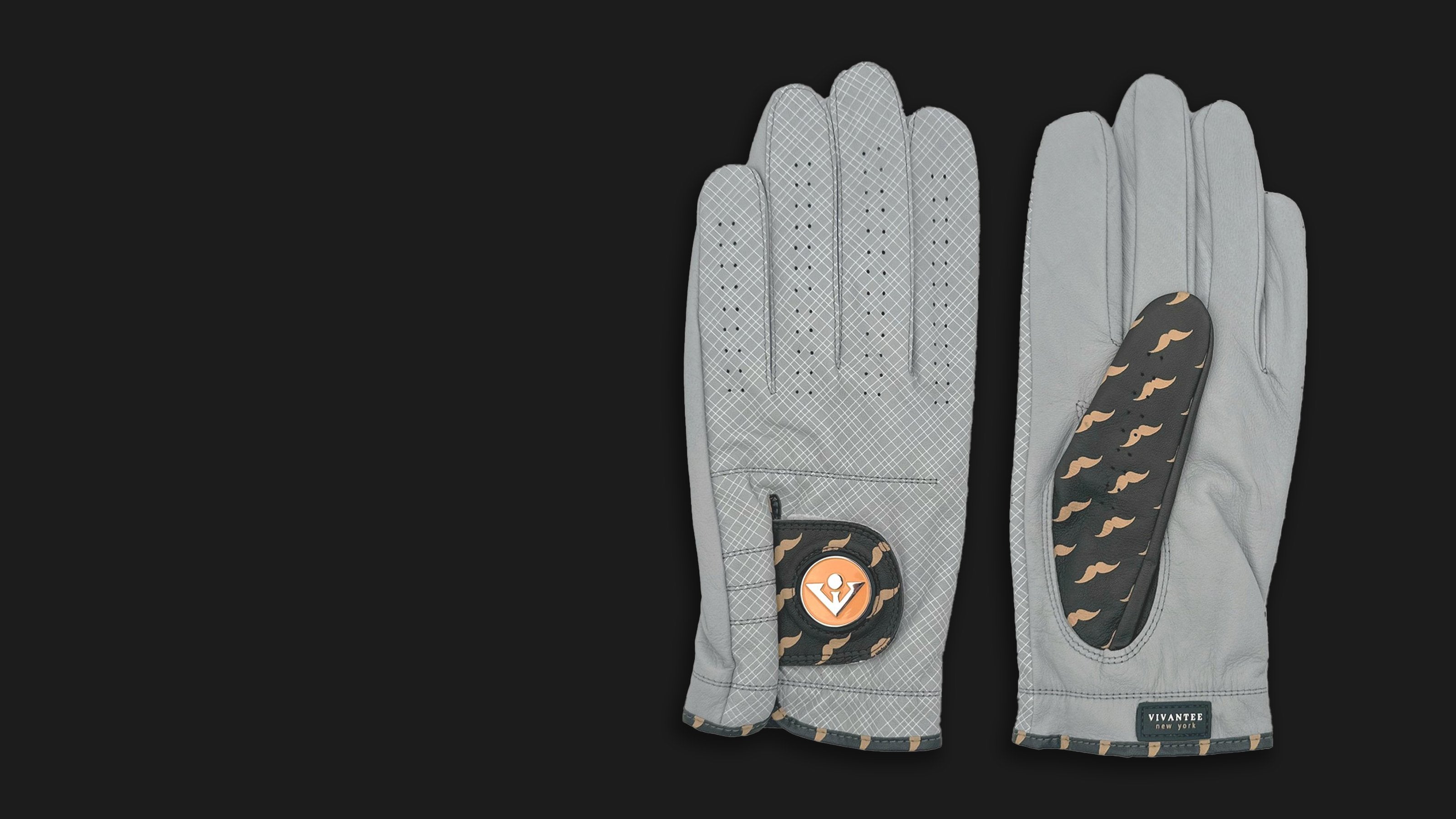 Unique charcoal mustache patterned golf gloves with magnetic ball marker laid out with a black background.