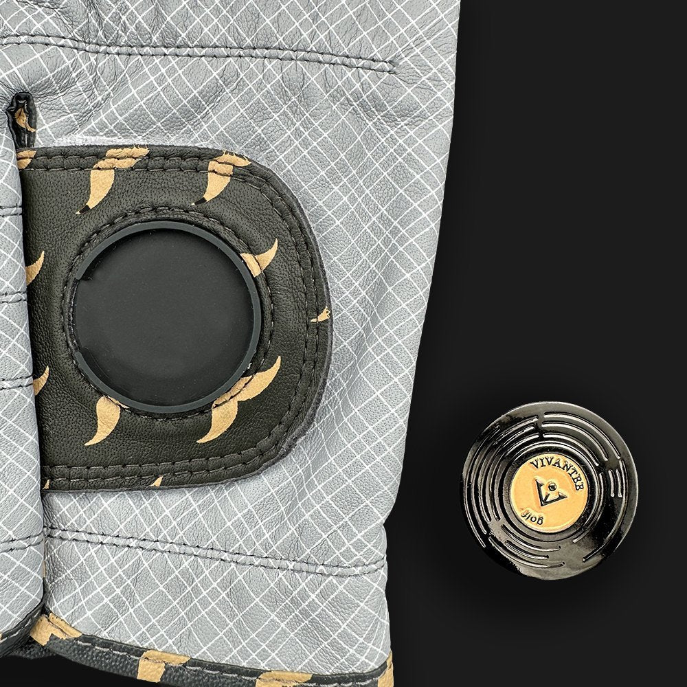 Close up of a gray golf glove with a vinyl record magnetic ball marker on a dark background by VivanTee Golf.