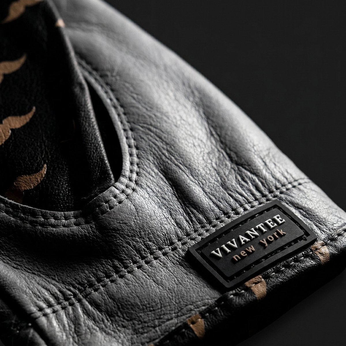 Gray golf glove with a black label reading 'Vivantee New York' on a dark background