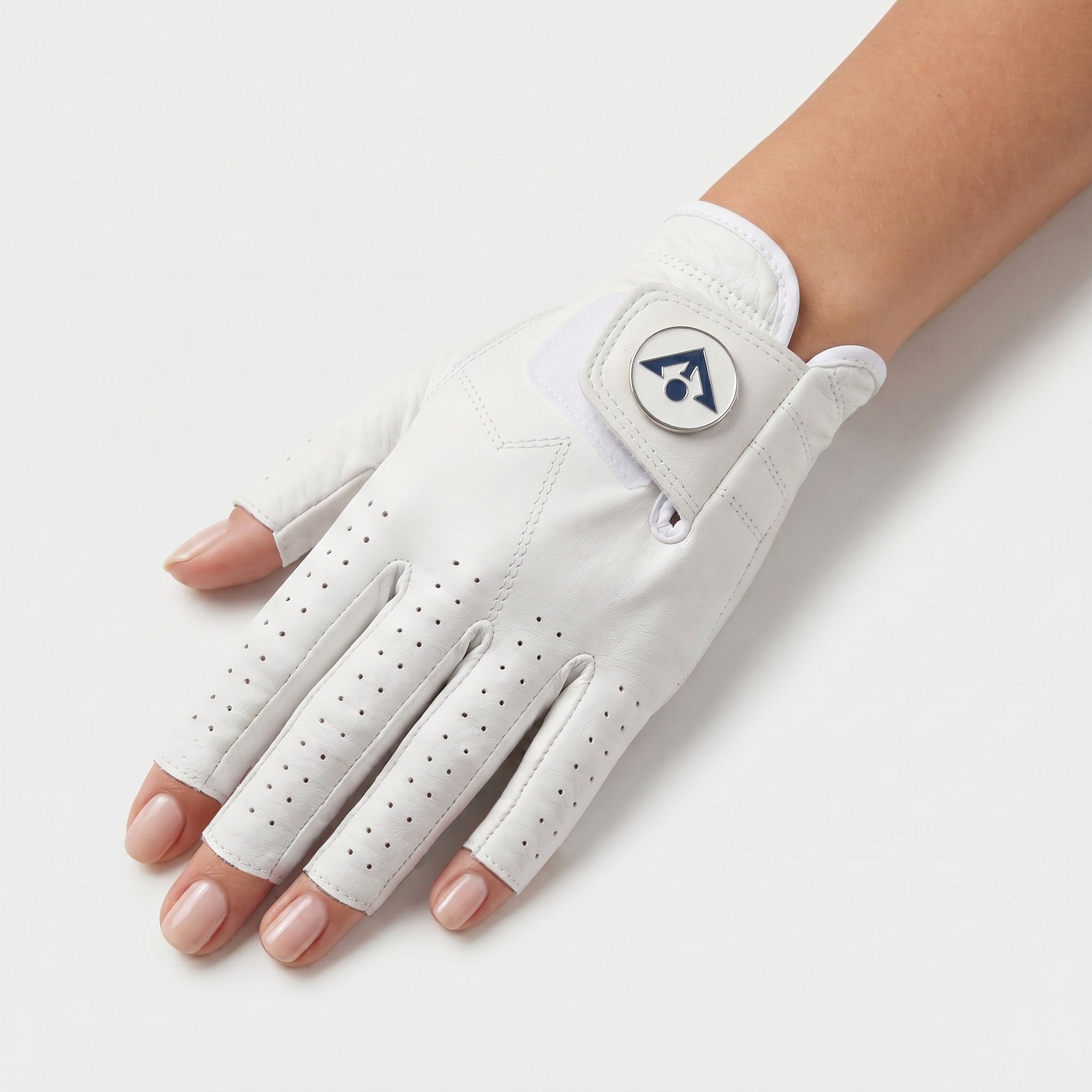 A white golf glove with perforated finger sections and a circular logo patch, shown on a model's hand against a light gray background.