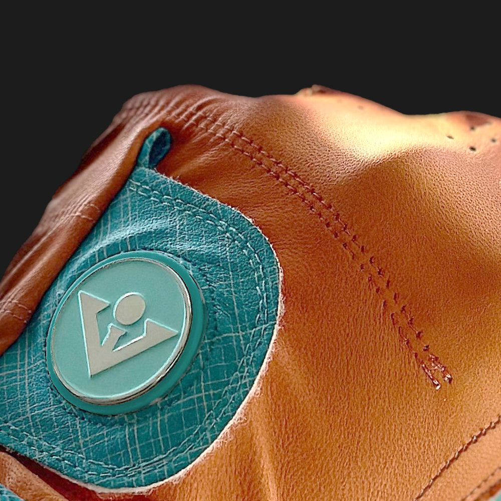 Close up of a magnetic ball marker on an orange golf glove. 