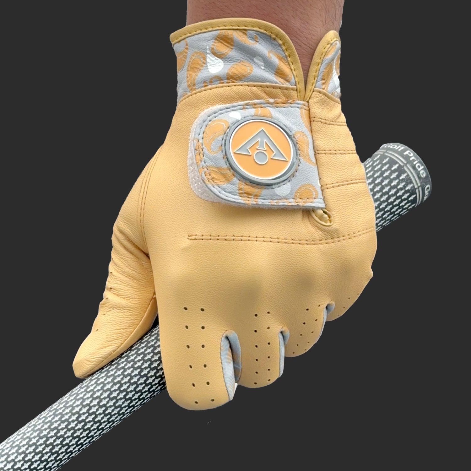 Yellow golf glove with paisley pattern by VivanTee Golf with a dark background.  