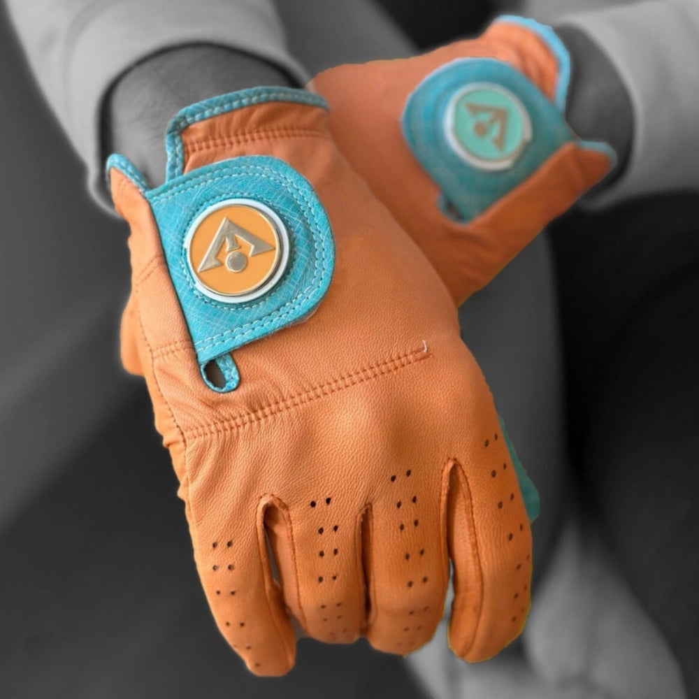 Unique golf glove in orange and blue accents posing with different colored ball markers with a black and white background.