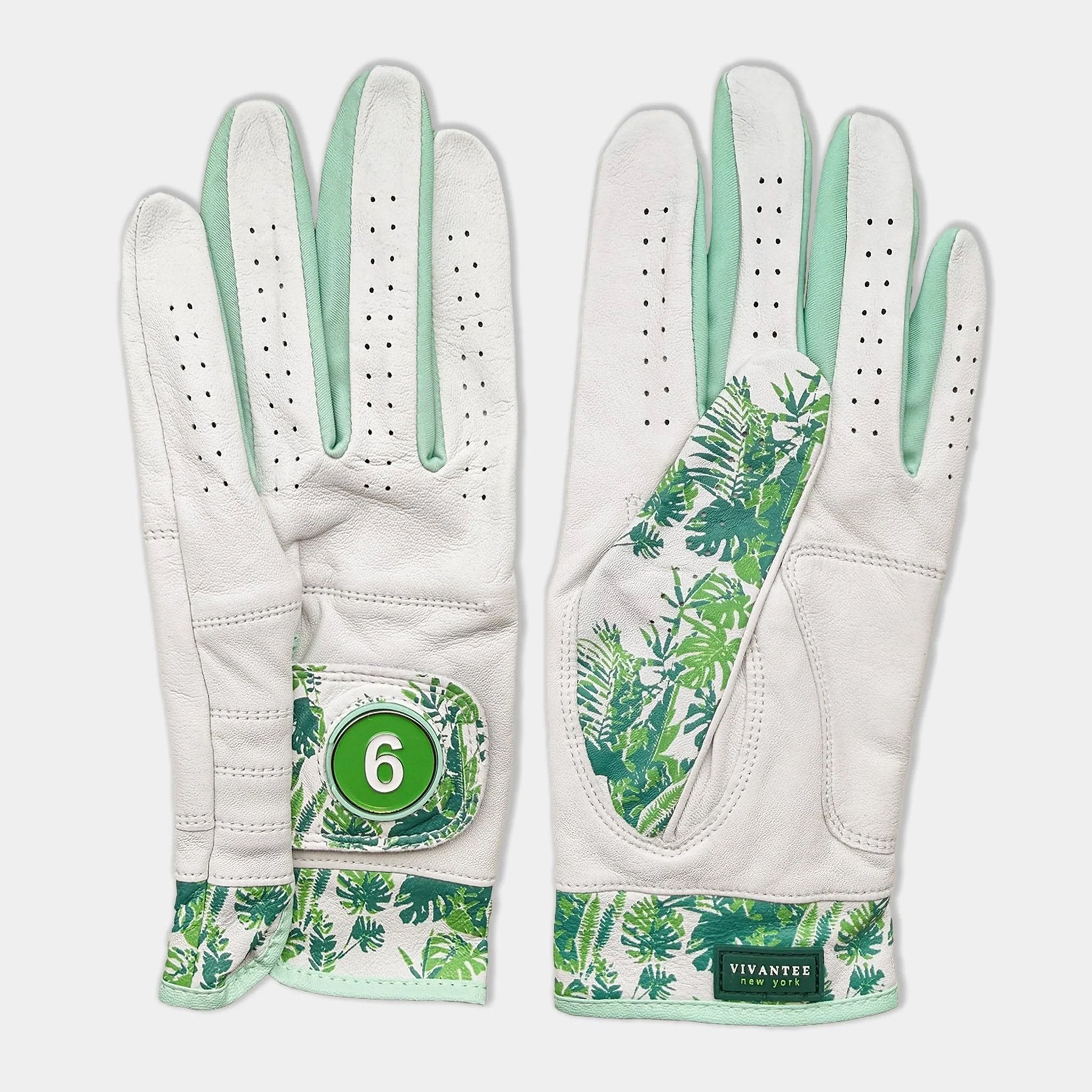 White golf glove with green leaf pattern and number 6 on a light gray background