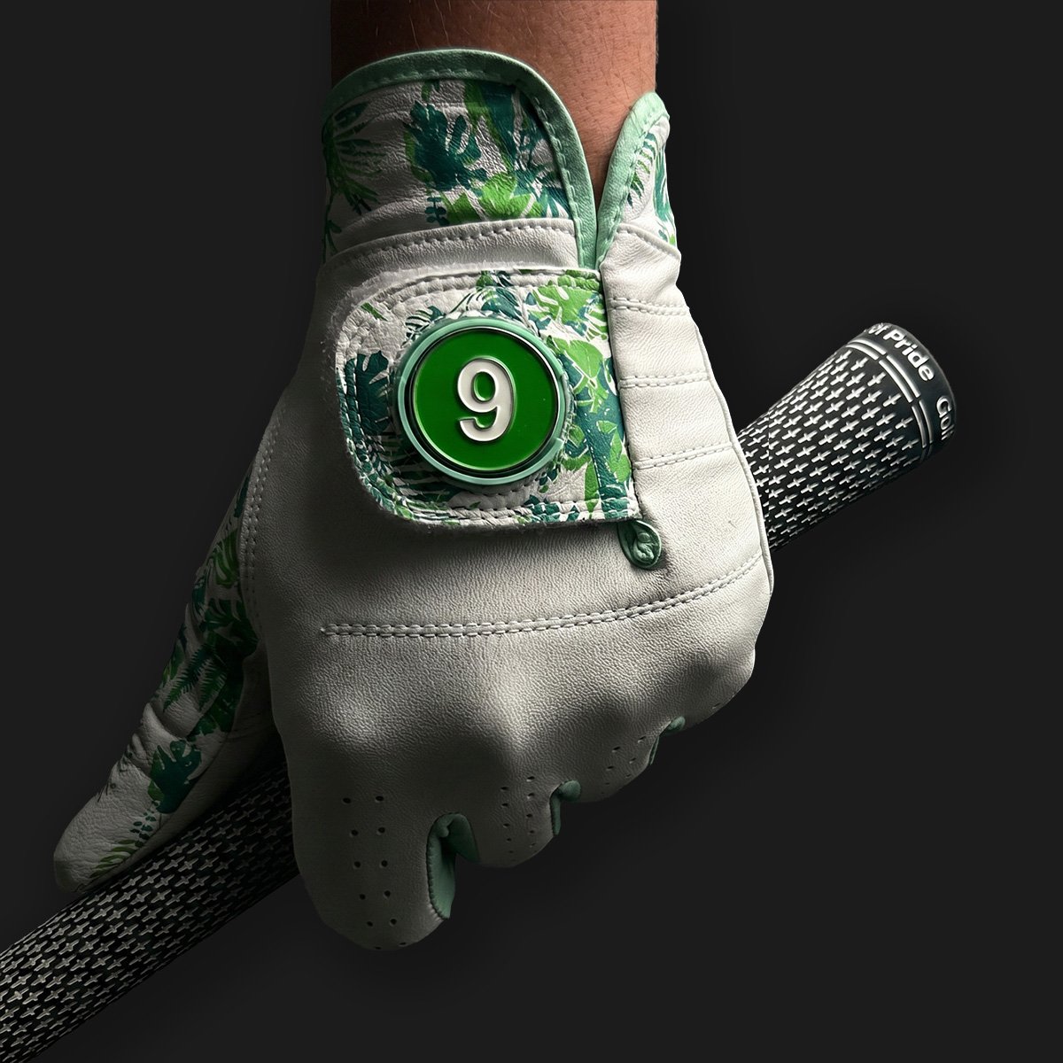 Golf glove with floral pattern and number 9 on a dark background
