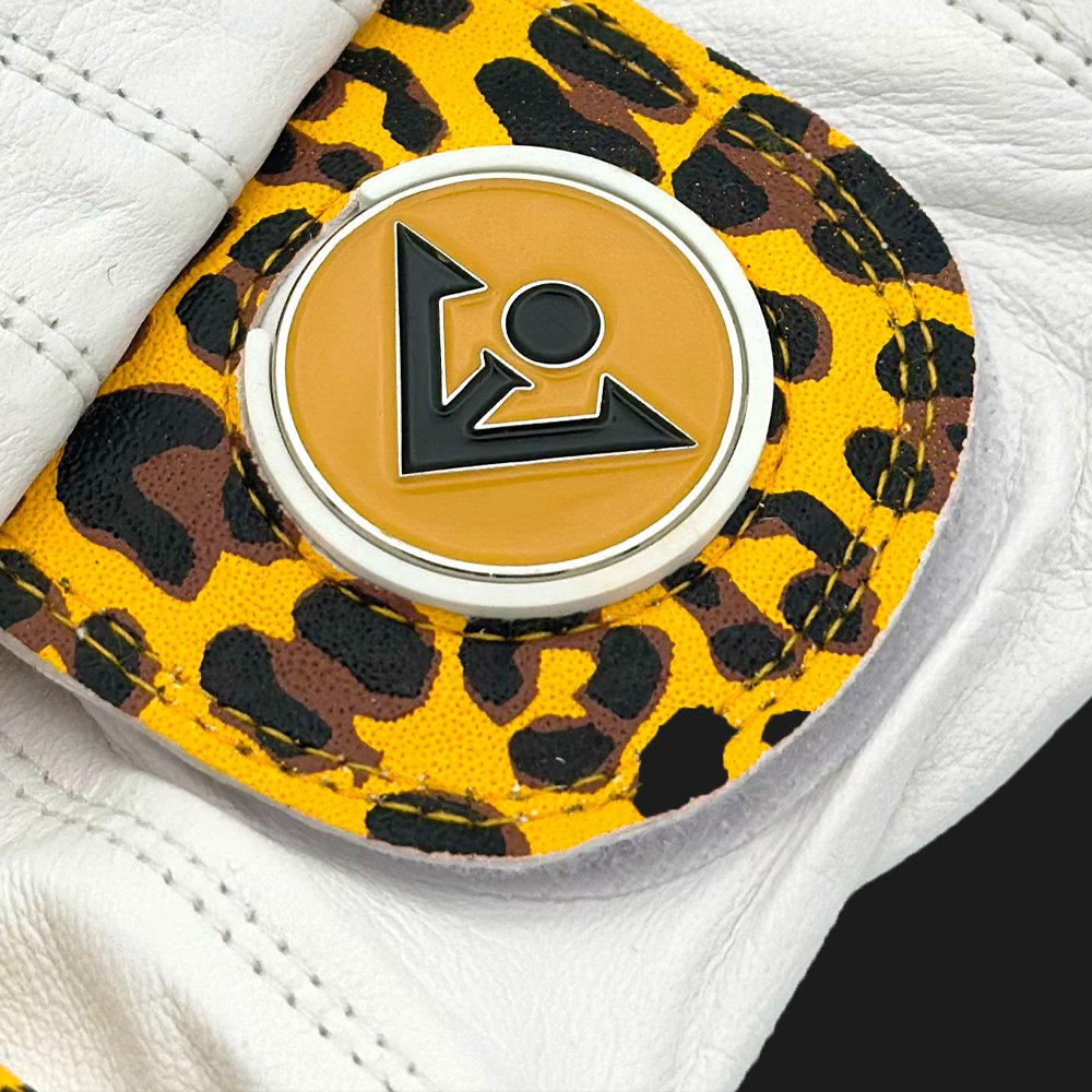 Yellow cheetah print golf glove with magnetic ball marker close up, showing the premium leather and stitching.  
