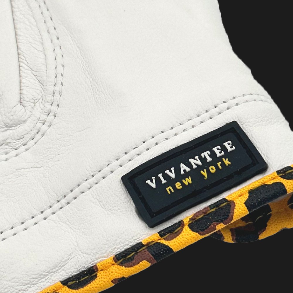 Close-up of a animal print golf glove with a 'Vivantee New York' label and leopard print trim.
