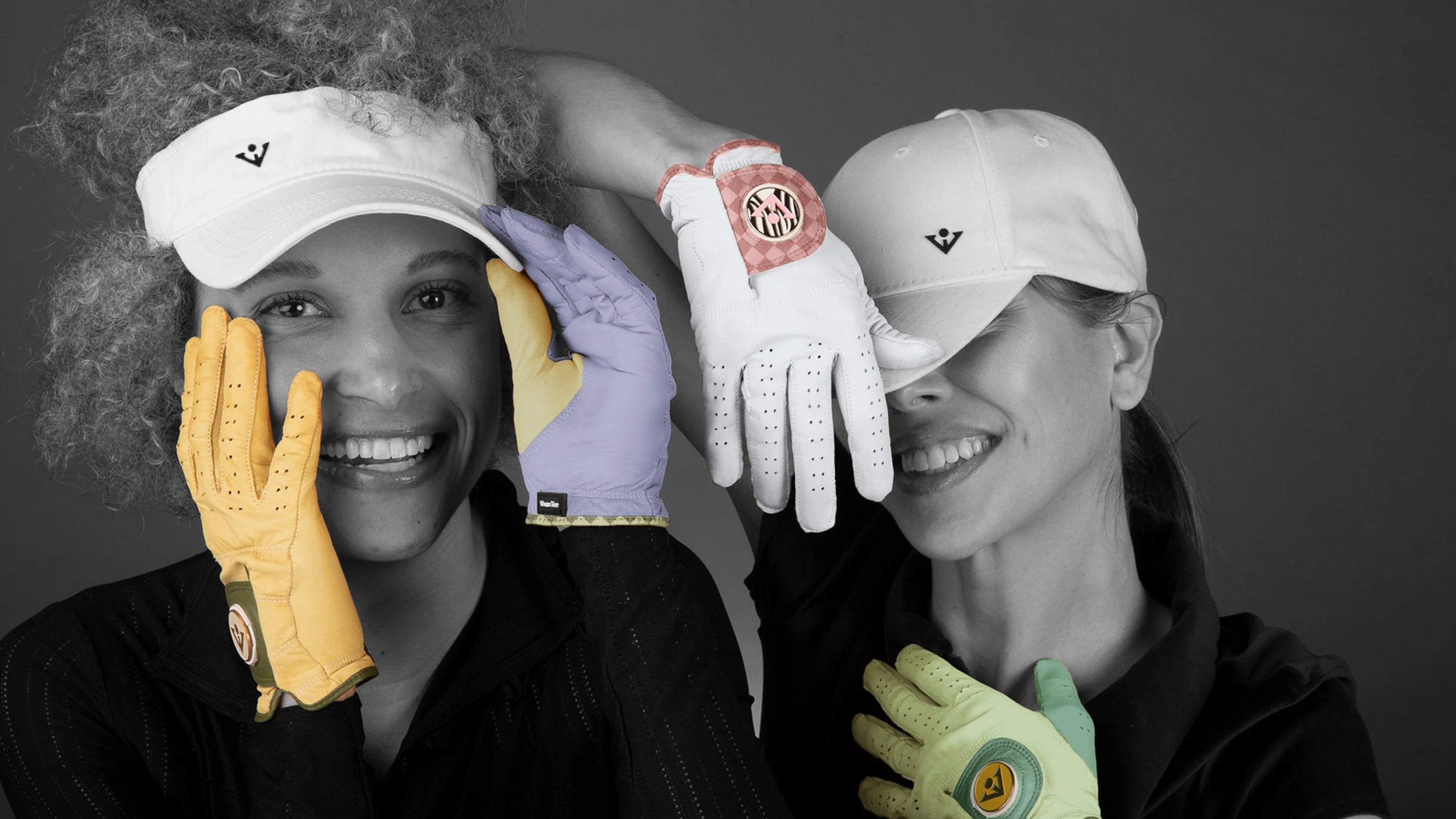 Two women wearing VivanTee Golf gloves with magnetic ball markers in different colors and posing in a fun outgoing way, with a monochromatic background showing the unique colored golf gloves.