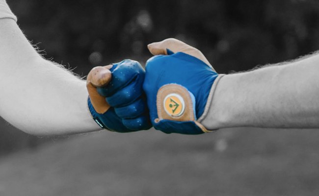 Two VivanTee golf gloves in navy blue and brown with magnetic ball markers, positioned as if fist-bumping, against a gray background.