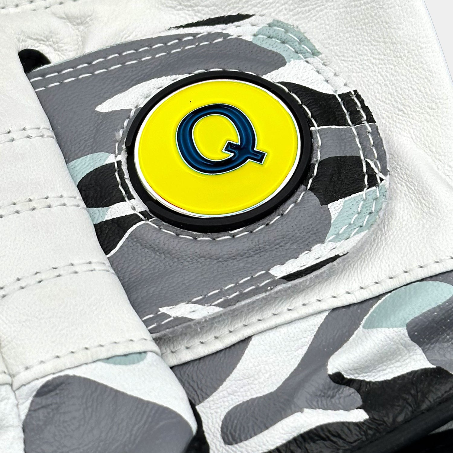 Close-up of a VivanTee Cabretta leather golf glove in gray camouflage with black palm reinforcement, designed for durability, grip, and style on the course.