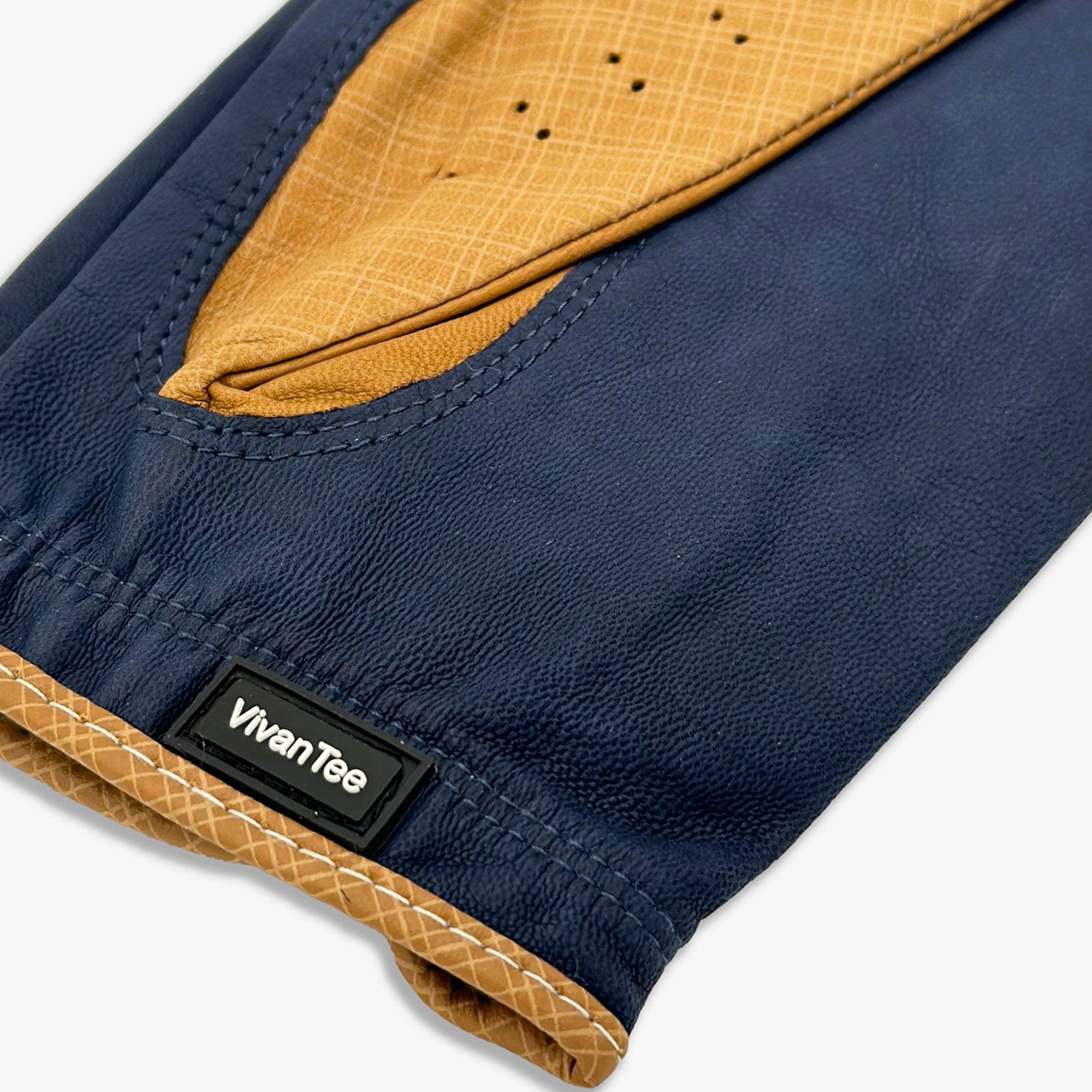 Close up VivanTee Golf pull tab on a navy blue and brown golf glove.