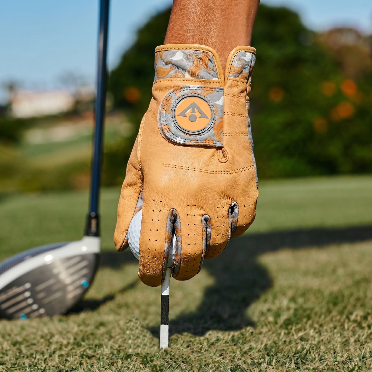 Women's Golf glove holding a golf club on a golf course