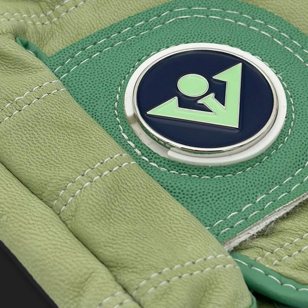 Up close shot of a unique golf glove in mint green showing the tab and magnetic ball marker.  