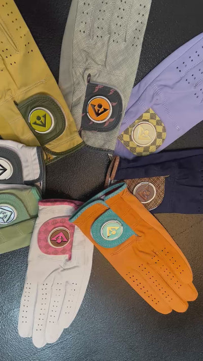 Video of various VivanTee golf gloves with magnetic ball markers in different colors and fashionable patterns, spread out in a circle on a table.