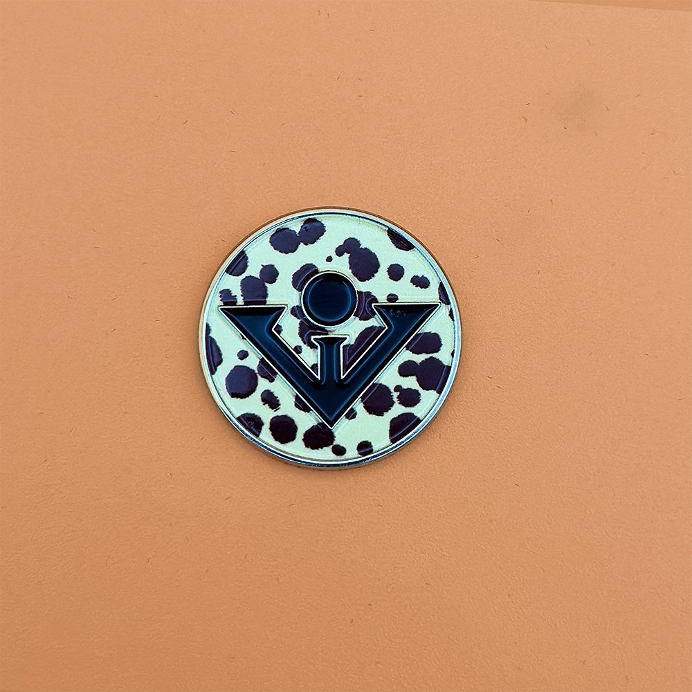 A cheetah print magnetic golf ball marker with an orange back drop, meant to be paired with our golf gloves with magnetic ball markers.
