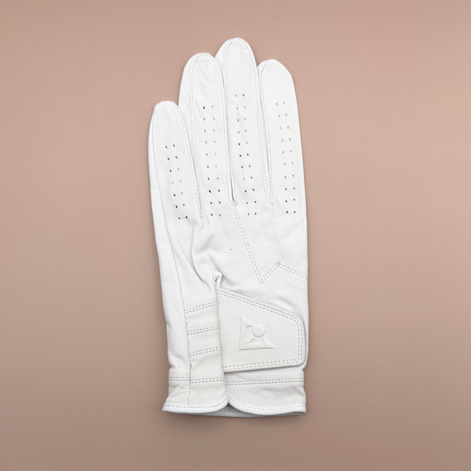 White leather golf glove with beige background by VivanTee Golf.  