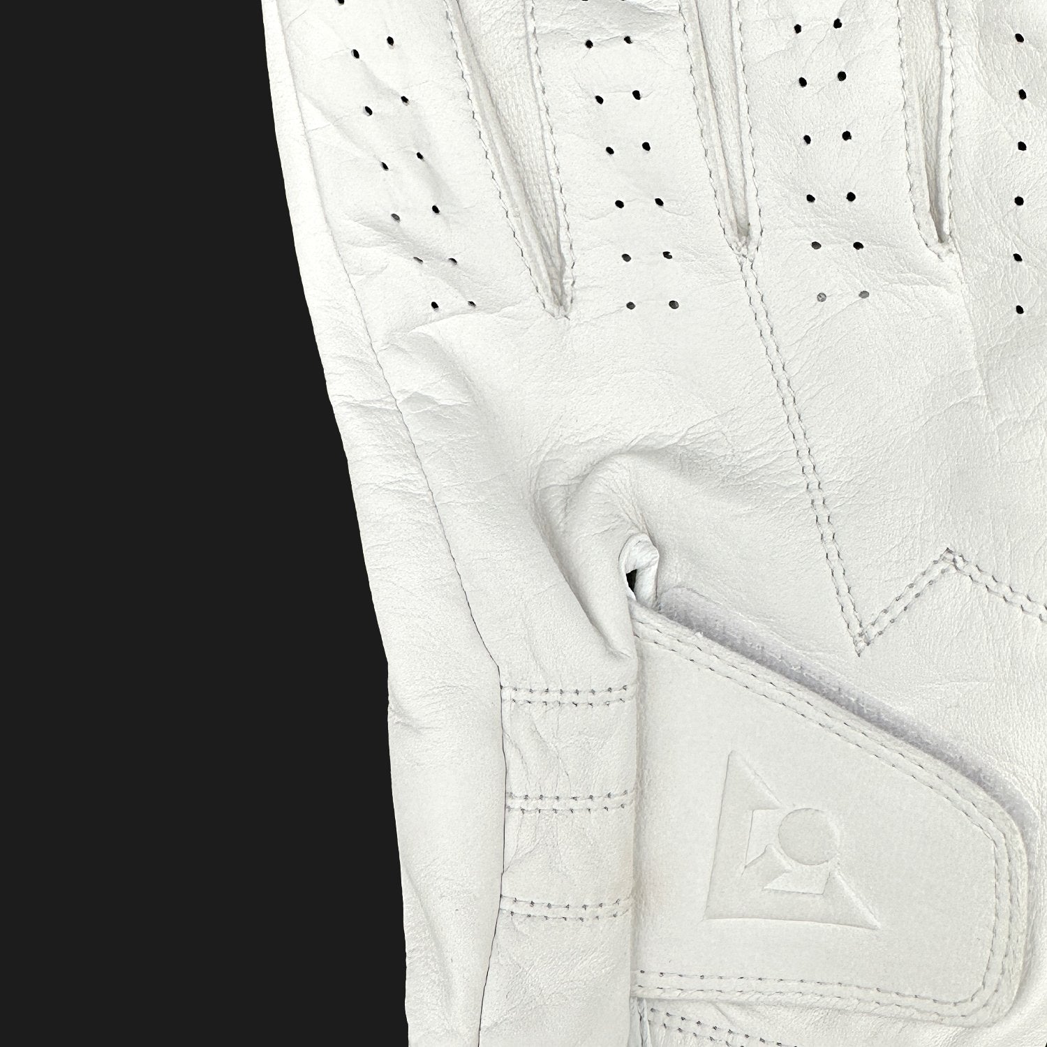 Close-up of a white golf glove with brand logo on a black background