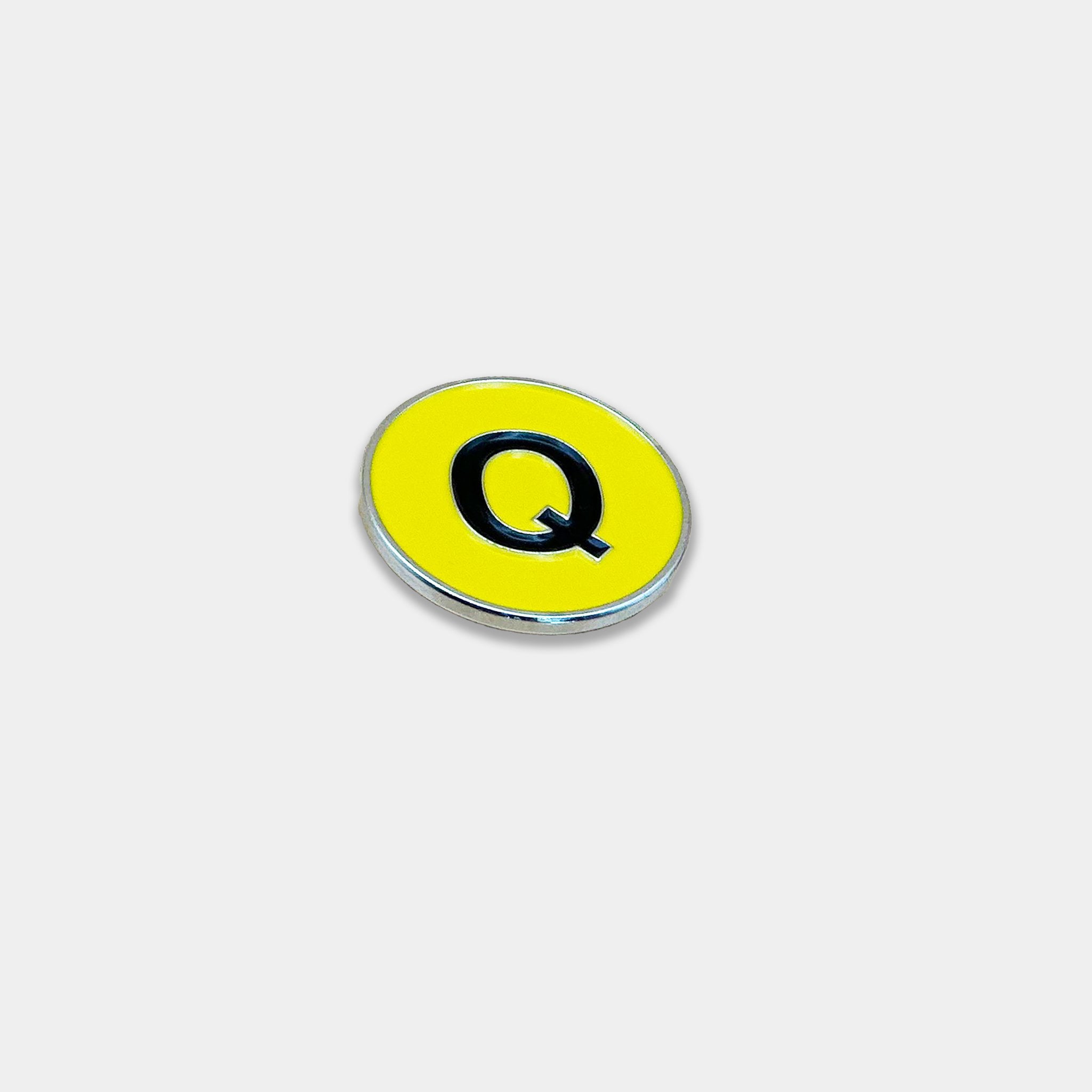 Q Train logo magnetic golf ball marker at a front angle view.